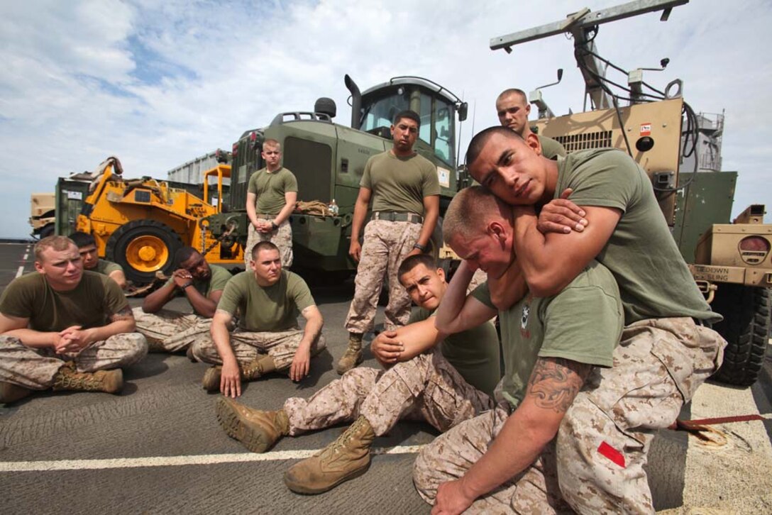 Sergeant Andy Alonso, landing support chief, Landing Support Section, Transportation Support Detachment, Combat Logistics Battalion 15, 15th Marine Expeditionary Unit, demonstrates a choke hold on Cpl. Courtland Lambert, a landing support specialist with the unit, while instructing Marines in the Marine Corps Martial Arts Program on the flight deck of the USS Rushmore, Aug. 16. The 15th MEU is embarked as part of the Peleliu Amphibious Ready Group during Certification Exercise, their final training before their deployment this fall. Alonso, 25, is from New York City and Lambert, 25, is from Clarksville, Tenn.