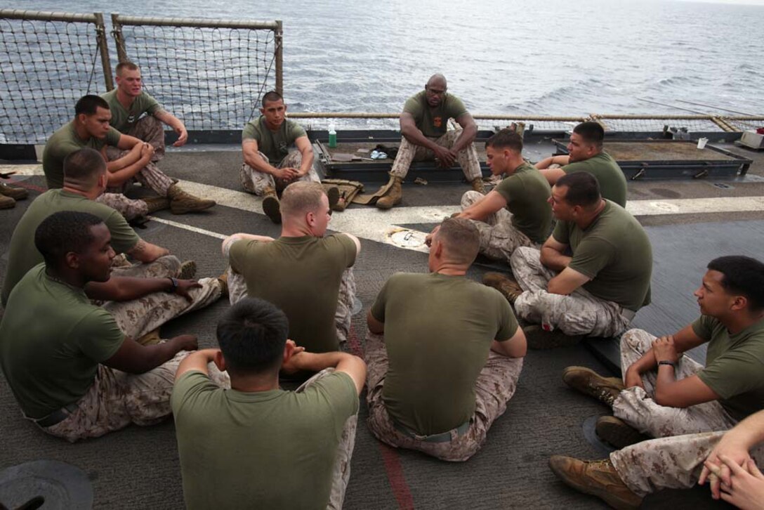 Marines from Combat Logistics Battalion 15, 15th Marine Expeditionary Unit, discuss the warrior ethos of the Marine Corps Martial Arts Program on the flight deck of the USS Rushmore, Aug. 16. The 15th MEU is embarked as part of the Peleliu Amphibious Ready Group during Certification Exercise, their final training before their deployment this fall.