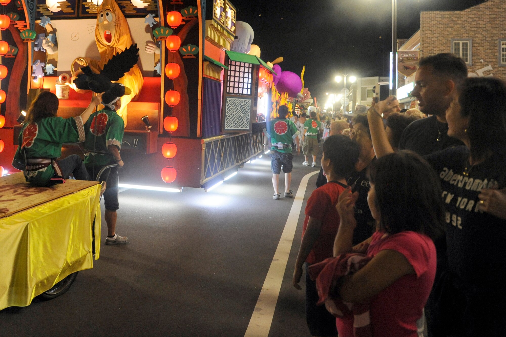 Misawa Air Base families take photos of decorated floats as they parade through downtown Misawa City, Japan, Aug. 19, 2011. Each float was made from scratch by members of the local community. This year, Misawa residents can watch the parade run in front of American Park outside the main gate Aug. 25. (U.S. Air Force photo/Tech. Sgt. Marie Brown)

