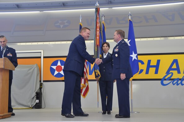 Col. Samuel C. Mahaney, right, commander, 452nd Air Mobility Wing, takes command of the 452nd Air Mobility Wing, March Air Reserve Base, Calif. from Major General Mark A. Kyle, left, commander, 4th Air Force. The flag symbolizes the transfer of authority from the old to the new commander. Command Chief Master Sgt. Ericka E. Kelly, wing command chief, assisted with the flag transfer.  (U.S. Air Force photo by Senior Airman Isis Ponce)