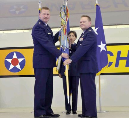 Col. Samuel C. Mahaney, right, commander, 452nd Air Mobility Wing, takes the wing flag from Major General Mark A. Kyle, left, commander, 4th Air Force. The flag symbolizes the transfer of authority from the old to the new commander. Command Chief Master Sgt. Ericka E. Kelly, wing command chief, assisted with the flag transfer. (U.S. Air Force photo / Senior Airman Isis Ponce)