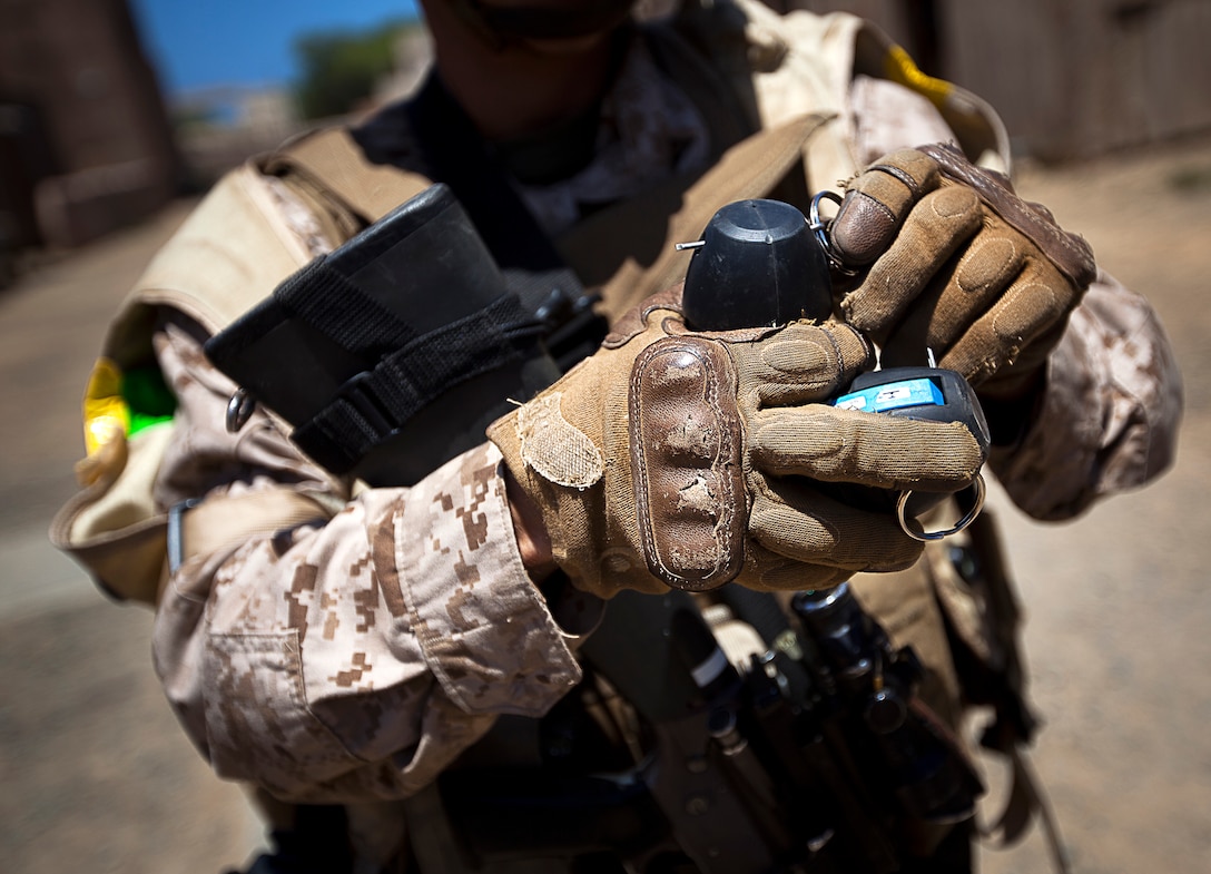 Lance Cpl. Tory Martin, a rifleman with 3rd Platoon, India Company, 3rd Battalion, 3rd Marine Regiment, and 20-year-old native of Twentynine Palms, Calif., replaces the safety pin of a Stingball grenade after using it during a non-lethal weapons training scenario in a simulated urban village on Marine Corps Training Area Bellows, Hawaii, Aug. 15, 2012. The training was part of a two-week test readiness review fielded by the Quantico, Va.-based Joint Non-Lethal Weapons Directorate and the Marine Corps Forces, Pacific Experimentation Center. The DoD Non-Lethal Weapons Program, headed by Commandant of the Marine Corps Gen. James Amos, trains operating forces on escalation of force options to minimize casualties and collateral damage, said Kelley Hughes, a directorate spokesperson.
