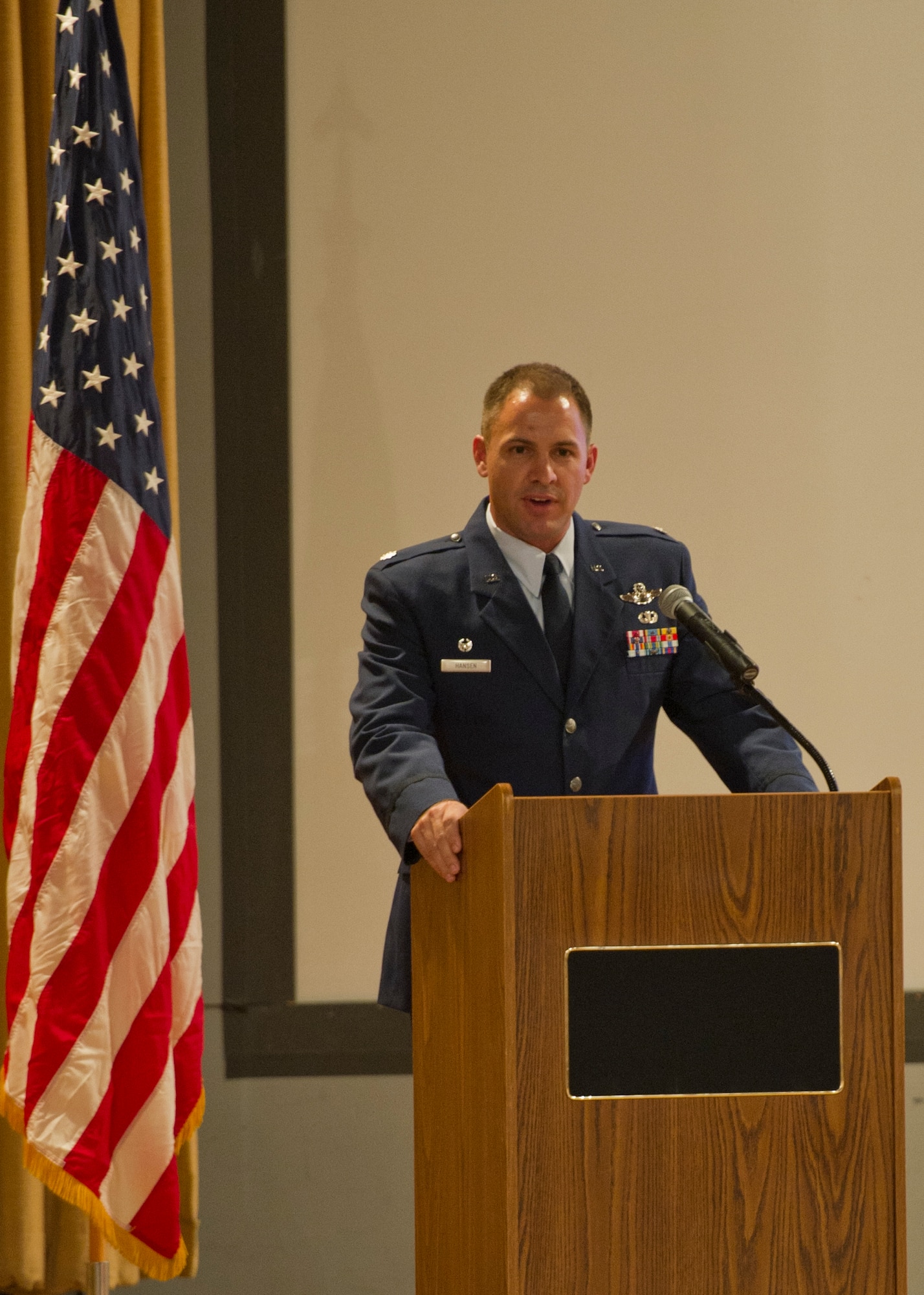 Lieutenant Col. Nathan Hansen, 29th Attack Squadron commander, speaks during an MQ-9 Reaper winging ceremony at the Holloman Air Force Base, N.M., base theater Aug. 16. The graduation ceremony marks the first time a student pilot in the Air Force Specialty Code 18X has completed the MQ-9 Basic Course without having been previously qualified in a manned aircraft. The basic course at Holloman AFB, which is about six months long, accounts for almost half of the total 18X training pipeline. (U.S. Air Force photo by Senior Airman Siuta B. Ika/ Released)