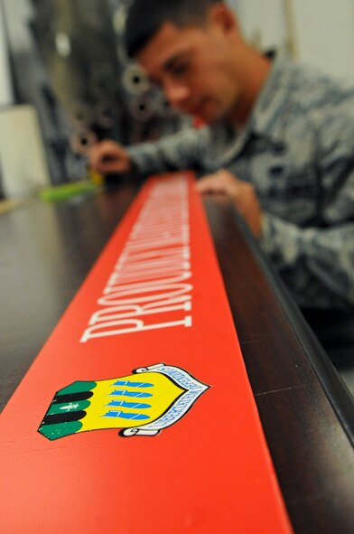 Senior Airman Robert Schwab, 2nd Maintenance Squadron, inspects his work on Barksdale Air Force Base, La., Aug. 20. Schwab custom created a sign to be placed on an aircraft chalk for the B-52D Stratofortress parked at the Eighth Air Force Museum. To create the design, Schwab used a thin layer of sheet metal and a layer of red vinyl topped with a cut out of the 2nd Bomb Wing logo and white text. Vinyl cutters are used to create graphics and tail markings for aircraft and equipment. (U.S. Air Force photo/Airman 1st Class Micaiah Anthony)(RELEASED)