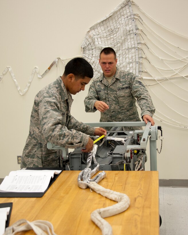 Staff Sgt. Aaron Cook (right), 452nd Operational Support Squadron aircrew flight equipment specialist, works through a training problem Aug. 20, 2012 at Sheppard Air Force Base, Texas.  Cook earned the coveted ACE award for achieving a 100 percent average during the 361st Training Squadron's Aircrew Flight Equipment apprentice course. (U.S. Air Force courtesy photo)
