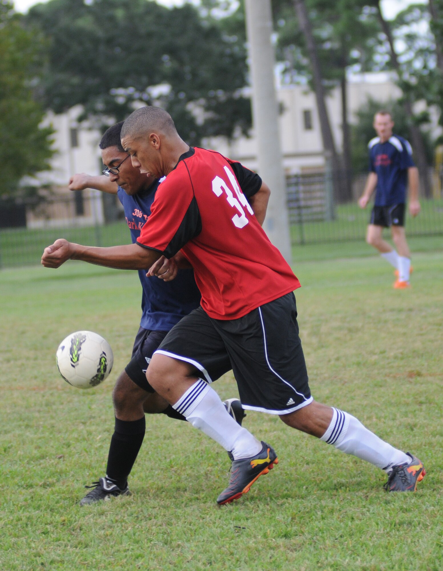 Roger Alvarez, 338th Training Squadron, battles for the ball with Zellie Dow, 335th TRS during an intramural soccer game Aug. 16, 2012, at Keesler Air Force Base, Miss.  The Dark Knights defeated the Bulls 4-3.  (U.S. Air Force photo by Kemberly Groue)