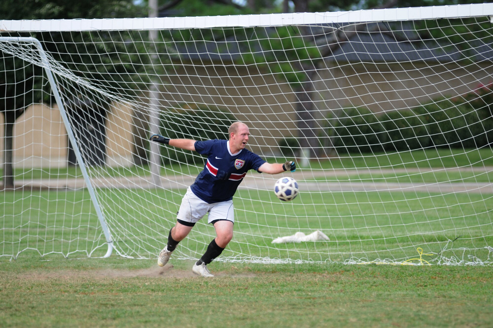 Joseph Gendron, 335th Training Squadron goalie, stretches out his arm in a failed attempt to protect the goal during an intramural soccer game against the 338th TRS Aug. 16, 2012, at Keesler Air Force Base, Miss.  The Dark Knights defeated the Bulls 4-3.  (U.S. Air Force photo by Kemberly Groue)