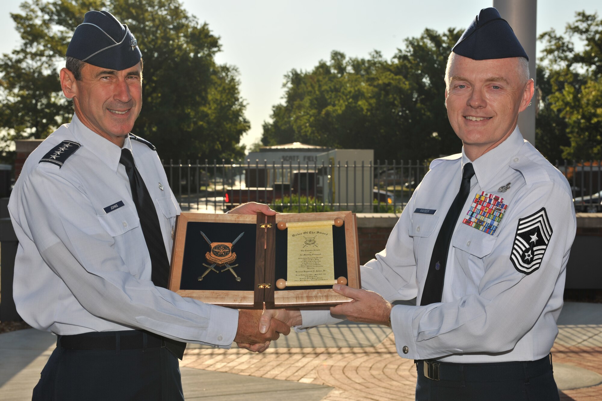 Chief Master Sgt. Andy Kaiser, Air Mobility Command command chief, presents Gen. Raymond Johns, AMC commander, an invitation to an Order of the Sword Ceremony Aug. 20, 2012, at Scott Air Force Base, Ill. Kaiser’s invitation was on behalf of the more than 39,000 Airmen that represent AMC. (U.S. Air Force photo/Jennifer Geggus) 