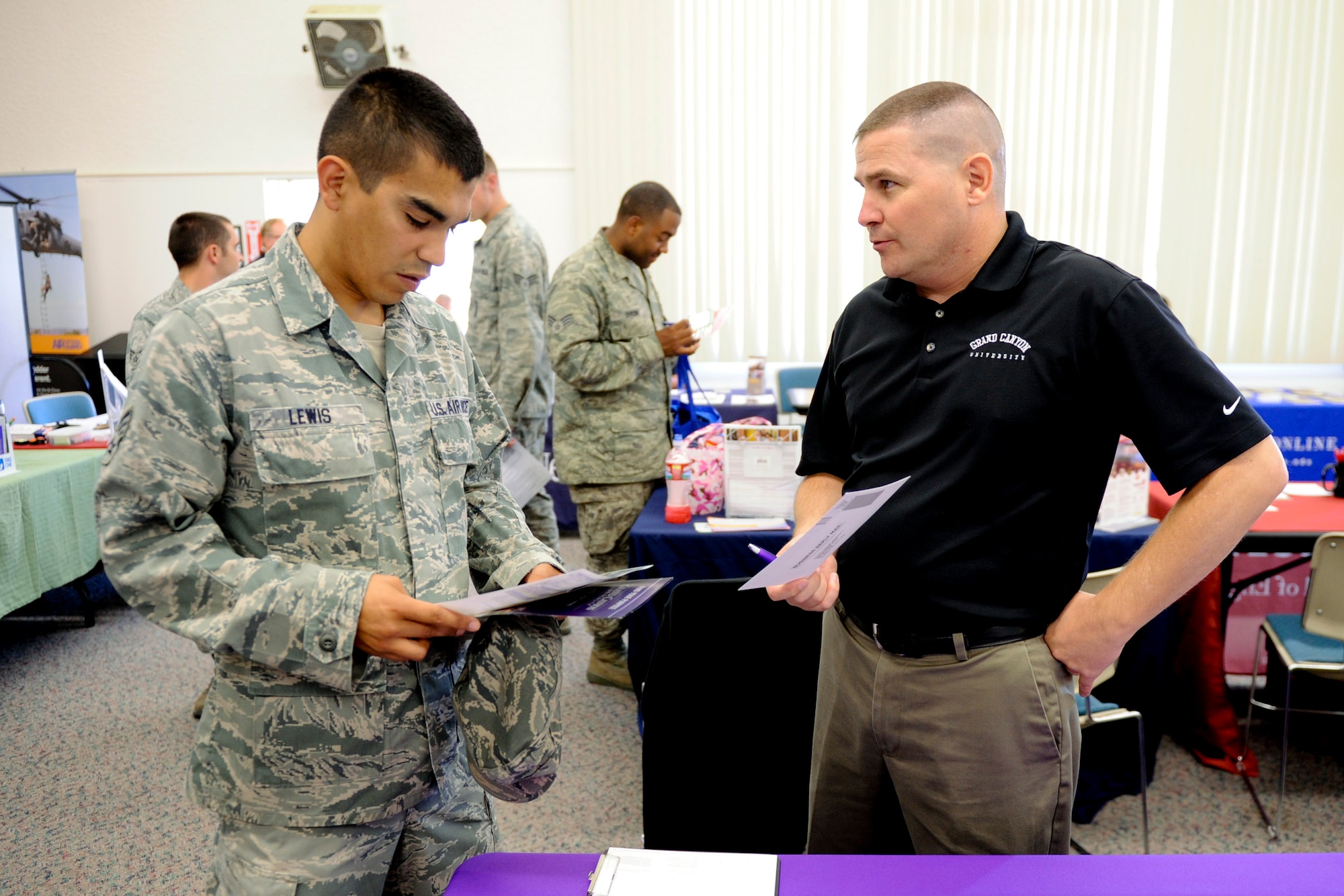 VANDENBERG AIR FORCE BASE, Calif. -- Senior Airman Christopher Lewis, a 30th Logistics Readines Squadron vehicle dispatcher, speaks with Rob Powell, a Grand Canyon University representative, at an education fair here Thursday, August 16, 2012. The fair, held at the Base Education Center here, had more than 50 colleges and programs present and was open to anyone with base access. (U.S. Air Force photo/Staff Sgt. Levi Riendeau)
