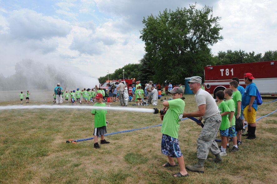 Staff Sgt. Ryan Goodrick, a firefighter from the 180th Fighter Wing, sprays water from a fire hose at White Star Park, Gibsonburg, Ohio, July 26, 2012 during a Boy Scout day camp.  Each year the camp program has a different theme; this year’s theme consisted of American Heroes, which included military members, Ottawa county Sheriff’s office, the Port Clinton police K9 unit and a local fire department underwater rescue team.  (U.S. Air Force photo by Senior Airman Amber Williams/Released)