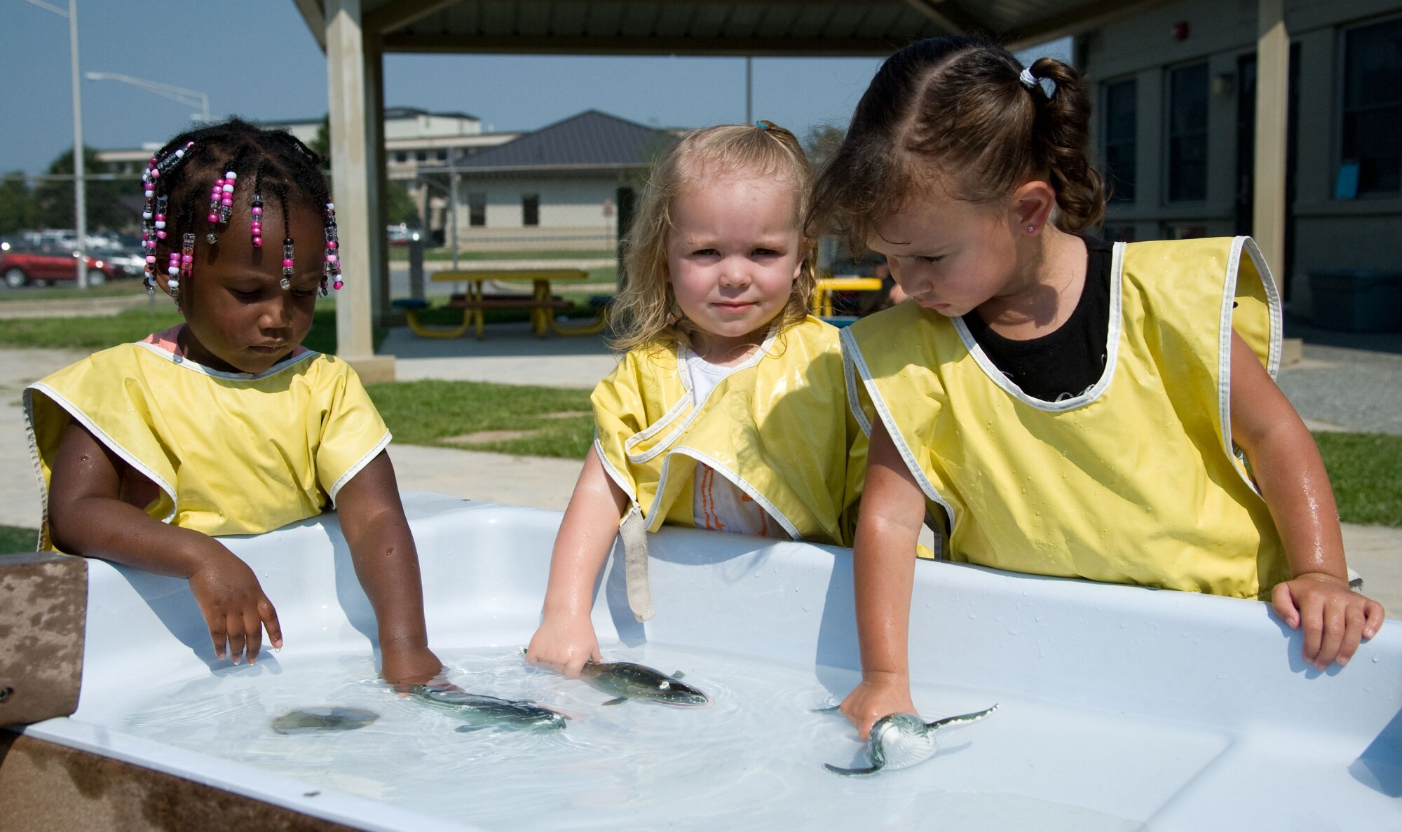 London Knight, Kierstynn Christoforo and Alyssa Woodall play in the water area Aug. 17, 2012, at the Child Development Center on Dover Air Force Base, Del. The CDC’s staff looks after more than 200 children. (U.S. Air Force photo by Adrian R. Rowan)
