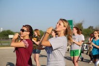 Shaye Wood (left) and Emily Poole, fro the Randolph High School band piccolo section, play warmup drills as the band practices in the early morning heat at Randolph,  Aug. 14. The band is learning fundamentals of drill to prepare for the upcoming marching season. (U.S. Air Force photo by Rich McFadden) 