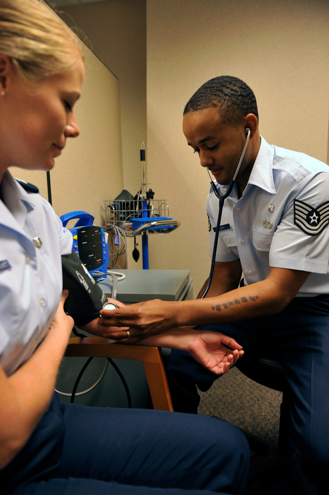 Tech. Sgt. Joseph Booker, a 19th Aerospace Medicine Squadron non commissioned officer in charge of force health management, checks blood pressure on a patient Aug. 13, 2012, at Little Rock Air Force Base, Ark. Booker oversees public health operations including deployment medical clearance, preventive health assessments and occupational health exams. (U.S. Air Force photo by Airman 1st Class Rusty Frank)