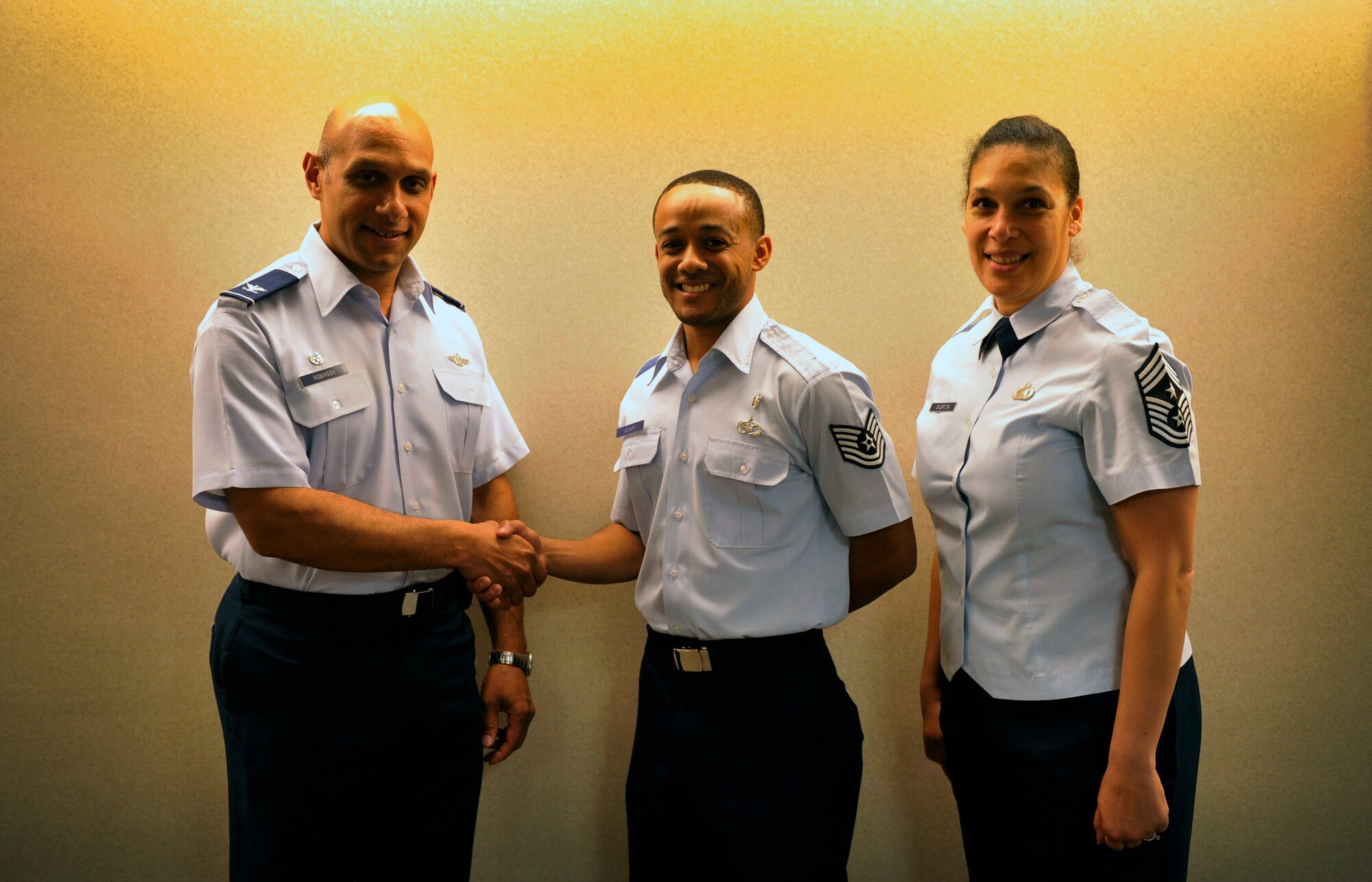Col. Brian Robinson, 19th Airlift Wing commander and Chief Master Sgt. Margarita Overton, 19th AW command chief, congratulate Tech. Sgt. Joseph Booker, a 19th Aerospace Medicine Squadron non commissioned officer in charge of force health management, for his selection as the Combat Airlifter of the Week Aug. 13, 2012, at Little Rock Air Force Base, Ark. Booker, a Landover, Md. native, is in charge of 10 staff members that executes Team Little Rock communicable disease, food safety and sanitation programs. (U.S. Air Force photo by Airman 1st Class Rusty Frank)
