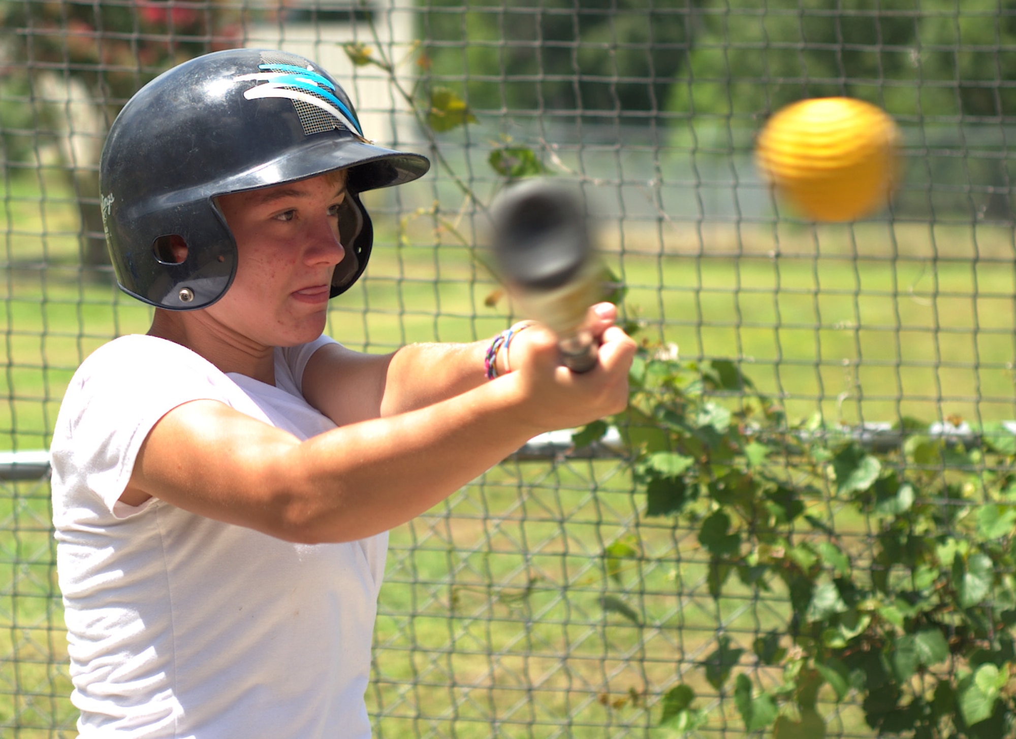 Talia Miller, 13, swings toward a ball in a batting cage at Fort Eustis, Va., Aug. 5, 2012. In addition to the cages, Eustis Outdoor Recreation personnel also provide go-kart rentals and a miniature golf course at the mini-park. (U.S. Air Force photo by Tech. Sgt. Barry Loo/Released)