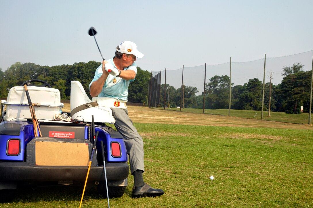 Dennis Walters demonstrates good swing form at the Andrews Leadership Series held at the Club at Andrews Aug. 17, 2012. Walters, his dog Bucky, and their assistant Asher Grogg, tour the nation as The Dennis Walters Golf Show. Their show encourages viewers to continually pursue their dreams despite life's challenges. (U.S. Air Force photo/Senior Airman Lindsey Porter)