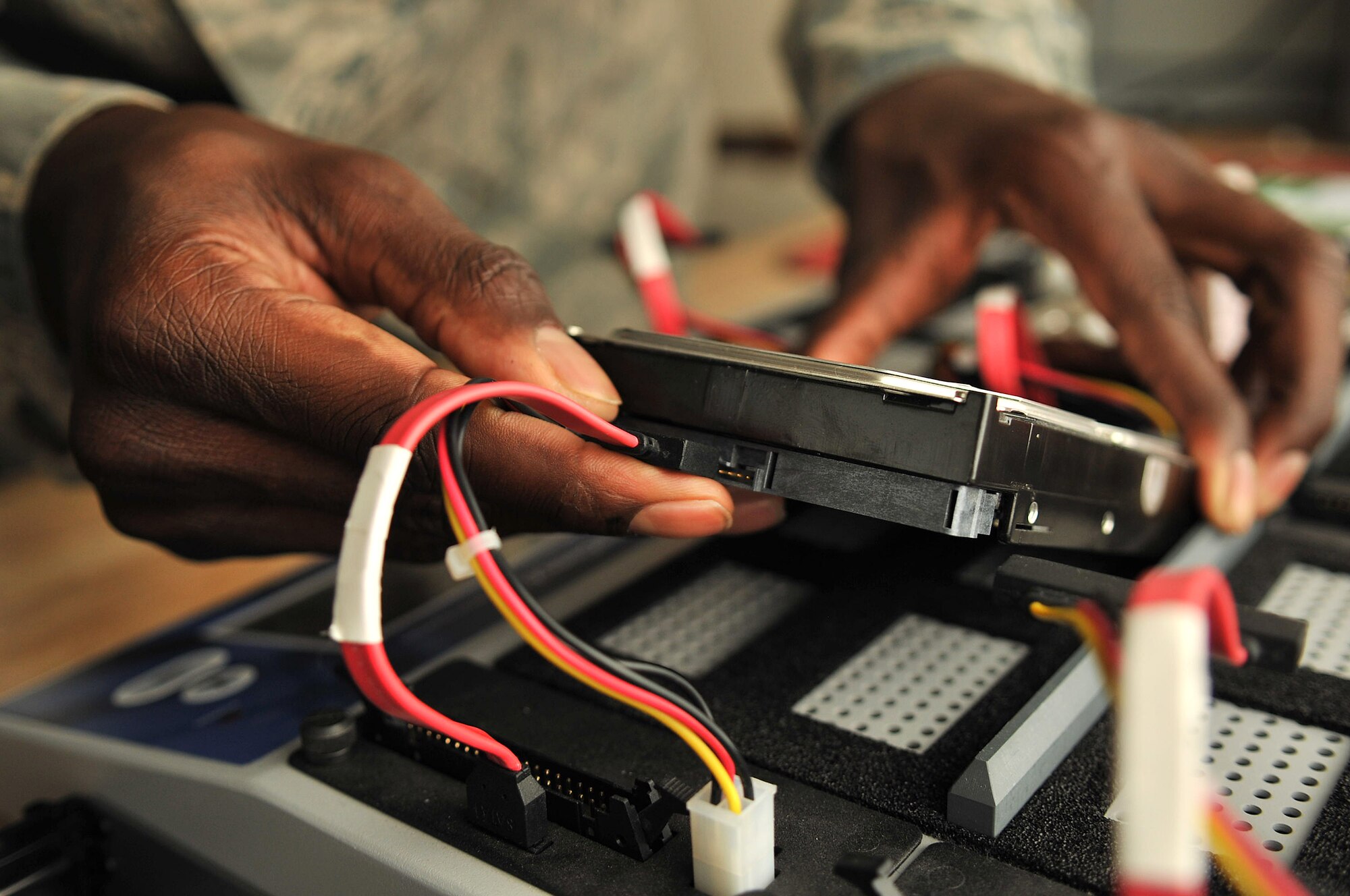 RAF MILDENHALL, England – Staff Sgt. Carrol Brewster, 100th Communications Squadron, clones a hard drive Aug. 16, 2012, in Bldg. 568. Brewster, and the rest of the client service center team, serve as the focal point for all base communications and are responsible for all direction, control and reporting of communication maintenance and network activities. (U.S. Air Force photo/Senior Airman Jerilyn Quintanilla)