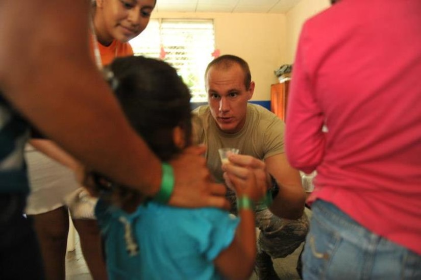 Air Force Staff Sgt. Michael Herrington, Joint Task Force Bravo, provides an oral deworming agent to a child during the second day of the Nicaragua MEDRETE in Wapi, Nicaragua, Aug. 17. Herrington was working with public health officials to distribute vitamins and pre-natal supplements to villagers. (Official photo by Tech. Sgt. Brannen Parrish)