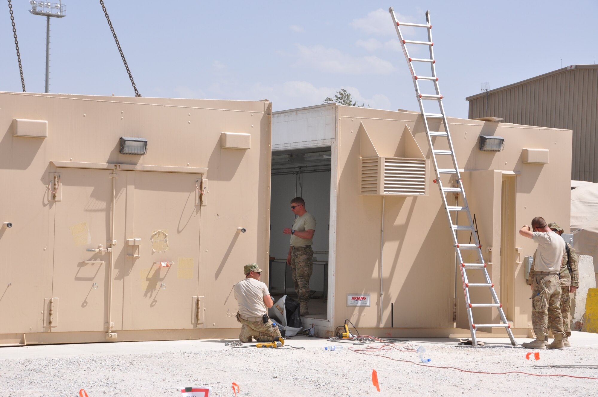Members of 455th Air Expeditionary Wing's Expeditionary Civil Engineer Squadron, Expeditionary Logistics Readiness Squadron, and Expeditionary Security Forces Squadron, work together to install the wing's new weapons armory August 8, 2012 at Bagram Airfield, Afghanistan. Knicknamed the "ARMAG,"  the new facility combined weapons from three temporary storage facilities into a more secure and climate-controlled building. (U.S. Air Force photo/TSgt Shawn McCowan)