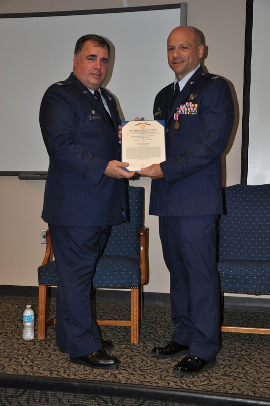 Colonel Terry Lawrence, 315th Airlift Wing Operations Group Commander, presents Colonel Michael Zachardo with a Meritorious Service Medal for his service as the 701st Airlift Squadron commander. Col Zachardo served as the 701st Airlift Squadron commander for four years. (U.S. Air Force Photo/1st Lt Joe Simms)