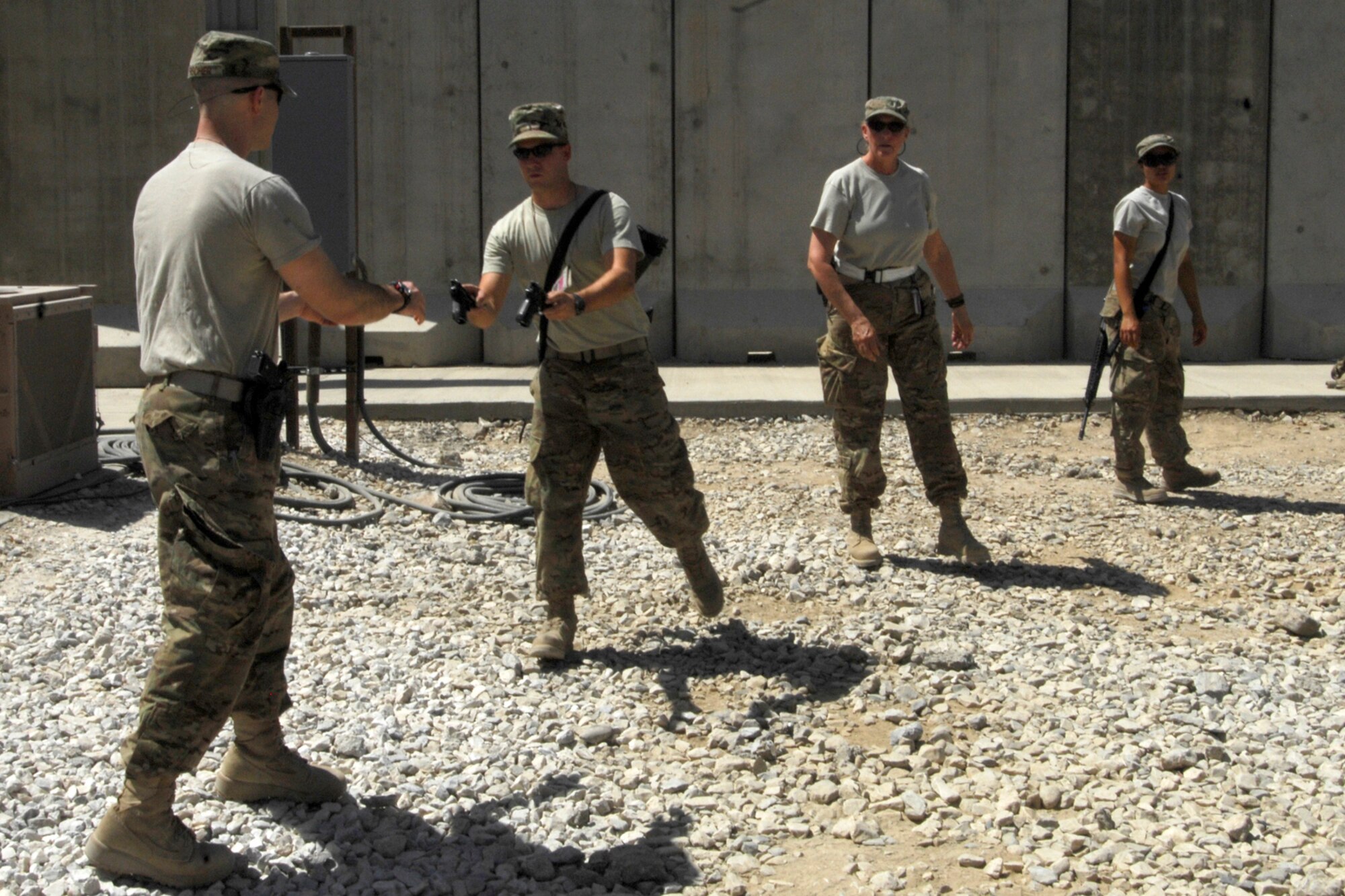 Airmen assigned to the 455th Air Expeditionary Wing form a line to pass weapons from temporary storage to a new armory in Camp Cunningham at Bagram Airfield, Afghanistan, Aug. 19, 2012. About 50 Airmen volunteered to move as many as a 1, 000 M-9s and M-16s from an older armory to a new, better equipped and more secure armory which is climate-controlled.  Weapons will be stored in the new hardened facility permanently. (U.S. Air Force photo/SSgt Jeff Nevison)