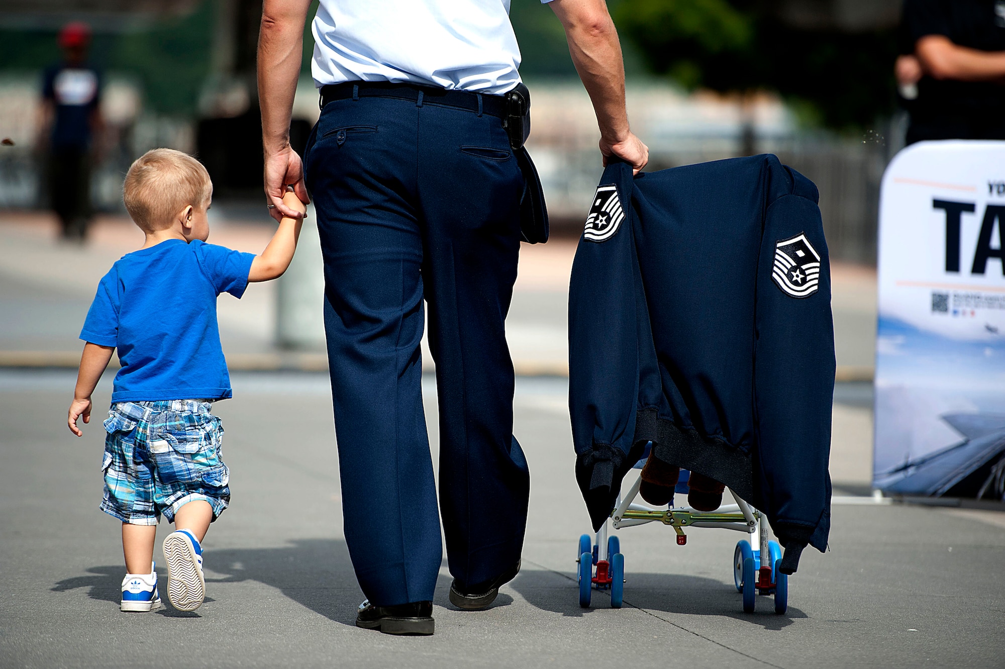 First Sgt. George Baker, of the 313th Recruiting Squadron in Syracuse, N.Y., walks with his son, Hunter, 2, through the exhibit area on Pier 86 during Air Force Week 2012 in New York City on Aug. 19. (U.S. Air Force photo/Senior Airman Andrew Lee) 
