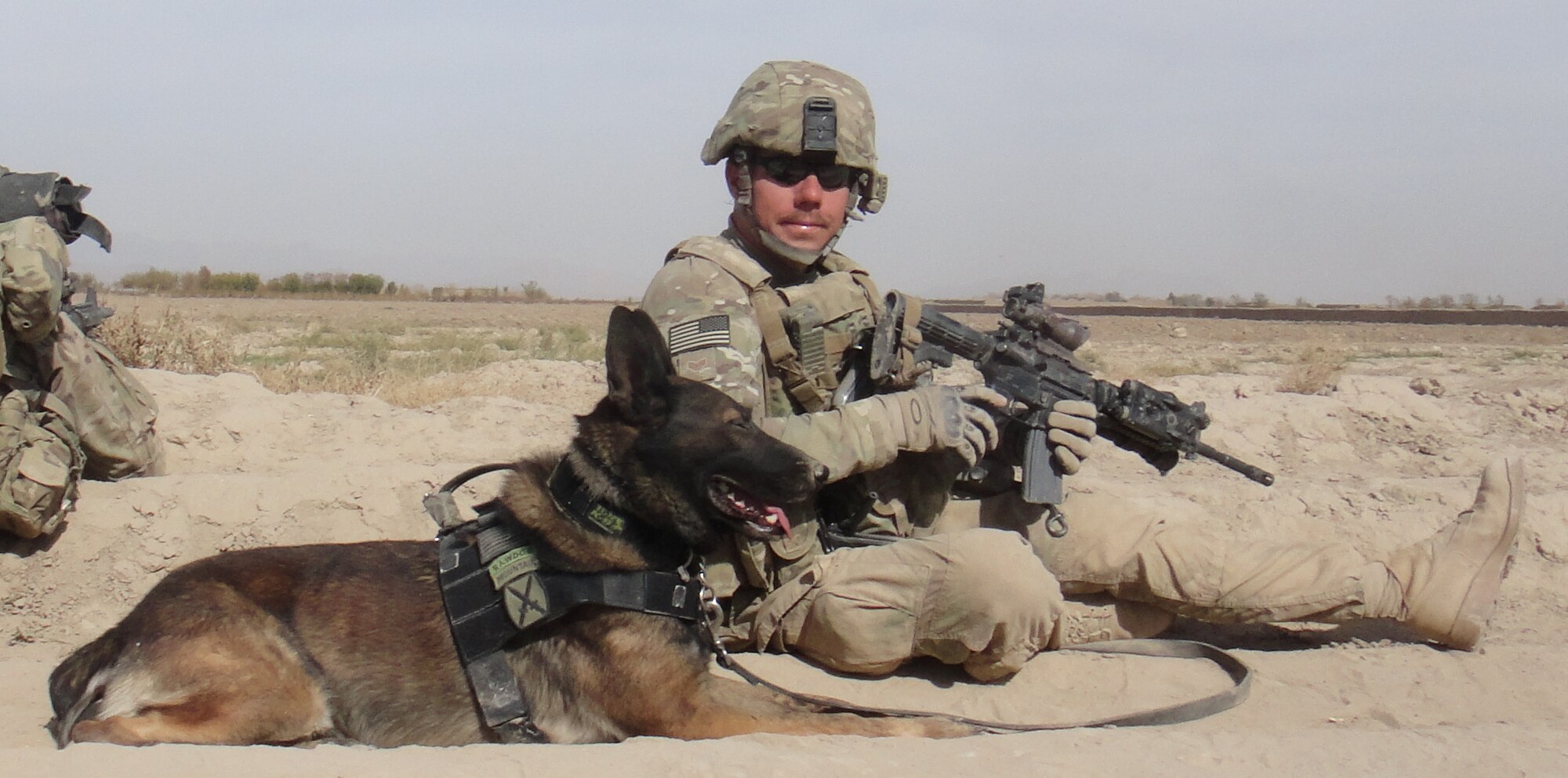 Staff Sgt. Christopher Jarrell, 81st Security Forces kennel master, poses for a photo with Military Working Dog, Toki, while deployed in Afghanistan.  Jarrell has been selected for the Secretary of the Air Force’s “Portraits in Courage” for 2012. (Courtesy photo.)
