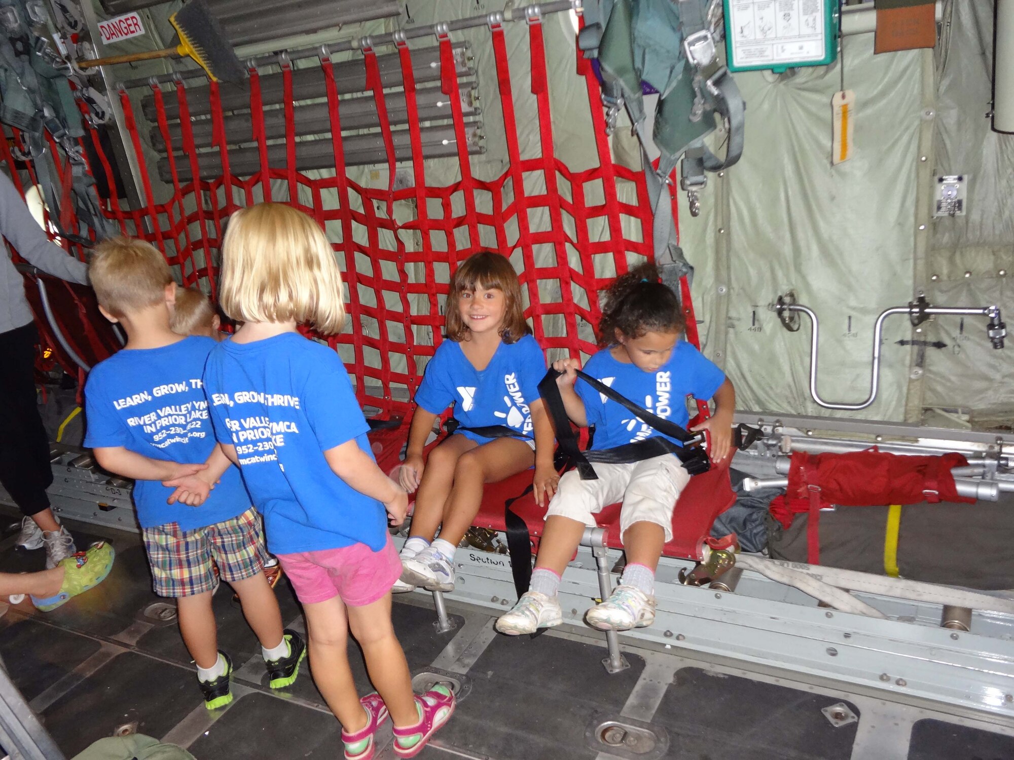 Campers from the Greater Twin Cities YMCA strap in to a C-130 aircraft during their tour Aug. 16. (Air Force Photo/Paul Zadach)