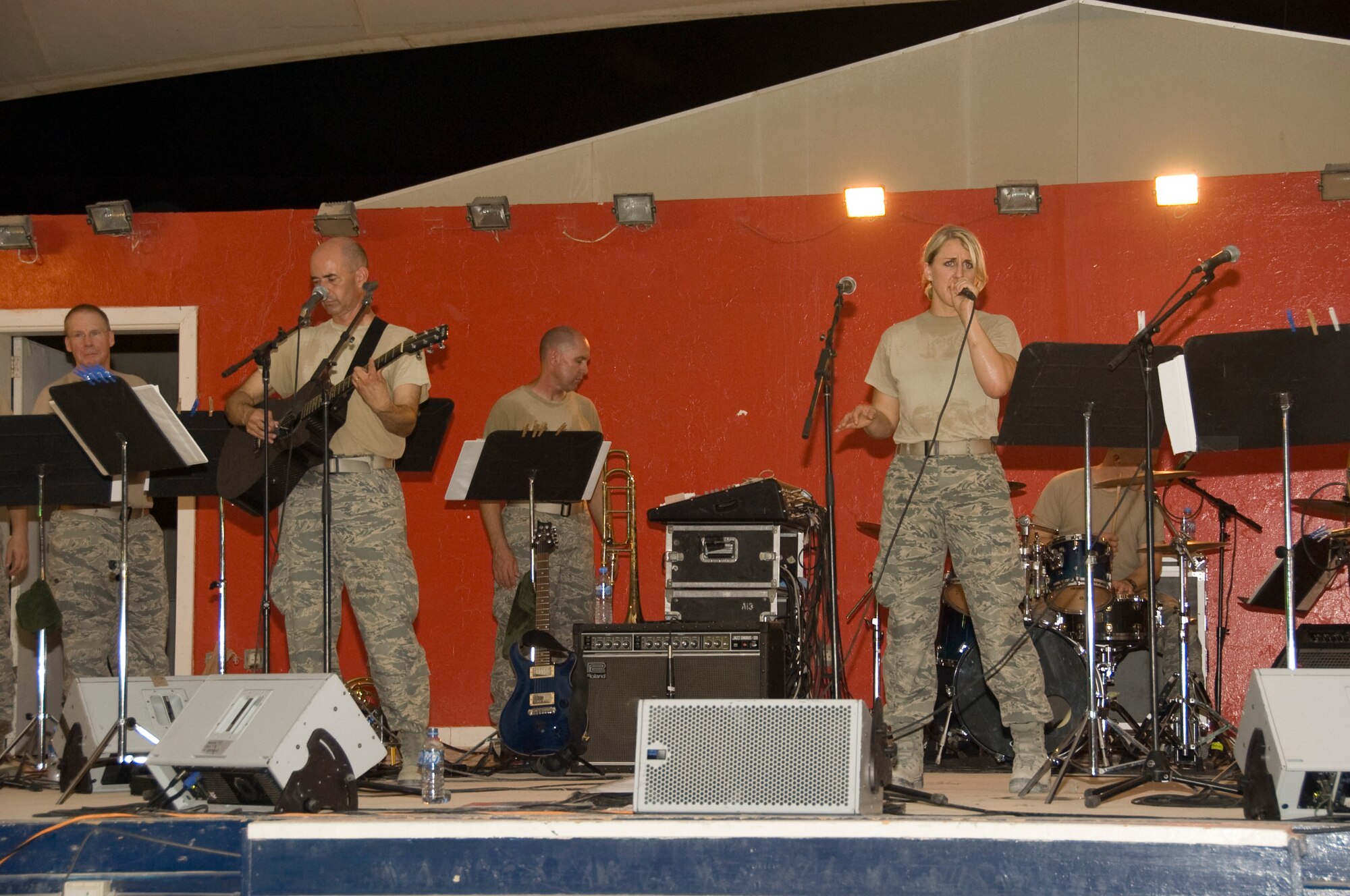 Senior Airman Jamie Horner, 379th Expeditionary Civil Engineer Squadron emergency manager, sings with the Air Force Central Band, Vector, during their final local performance Aug. 18 at Memorial Plaza. Horner began singing with Vector due to their lack of a female vocalist. Horner is deployed from Andrews Air Force Base, Md., and is a native of Redding, Calif. (U.S. Air Force photo/Senior Airman Bryan Swink)