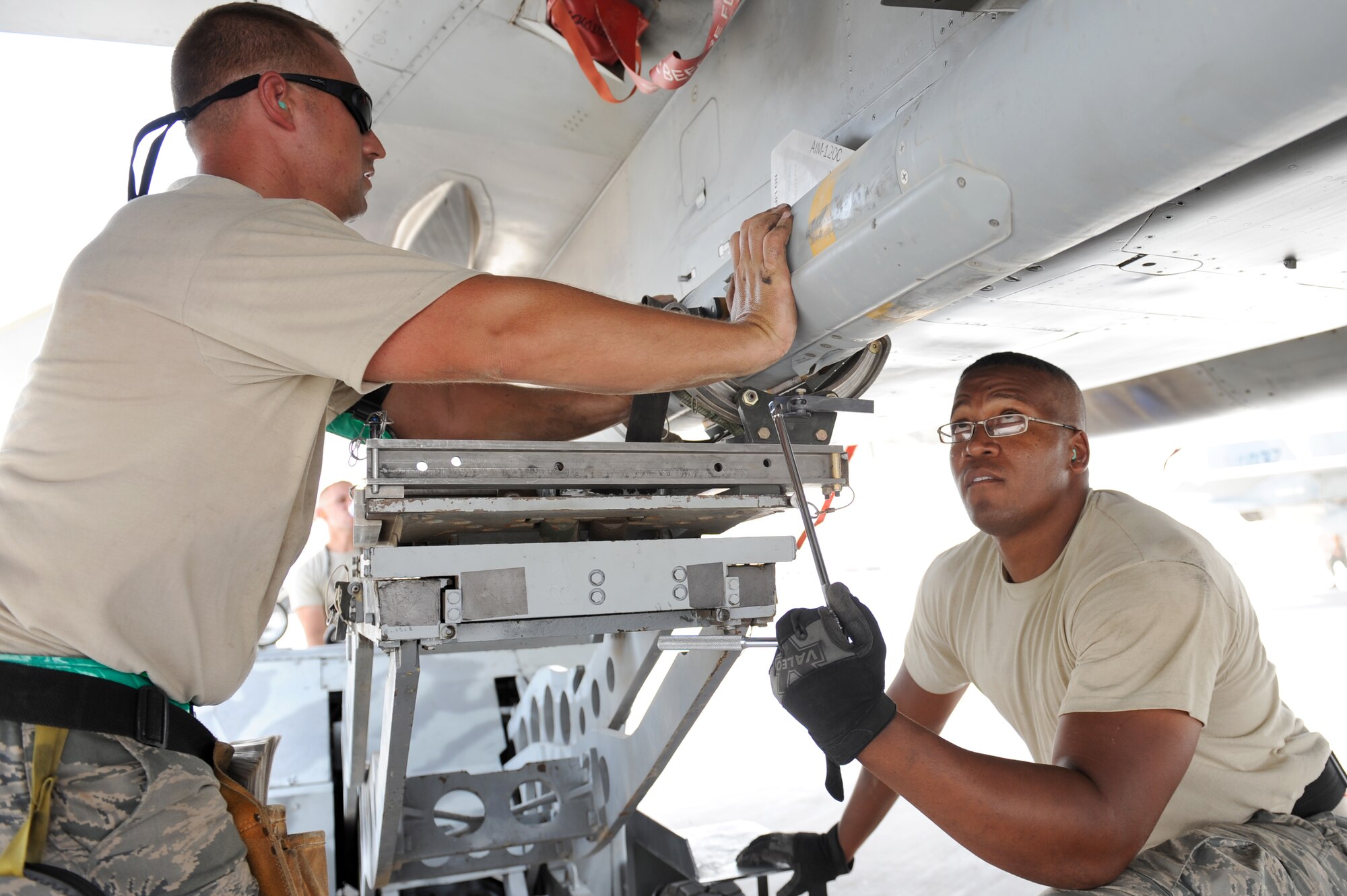 SOUTHWEST ASIA - U.S. Air Force Tech. Sgt. Brandon Orr holds a missile in place as Staff Sgt. Chad Lewis secures it during a generation exercise at the 380th Air Expeditionary Wing Aug. 17, 2012. Orr, a New Orleans native, and Lewis, a Petal, Miss., native, are 380th Expeditionary Aircraft Maintenance Squadron weapons loaders and are deployed from the Louisiana Air National Guard. (U.S. Air Force photo/Master Sgt. Scott MacKay)