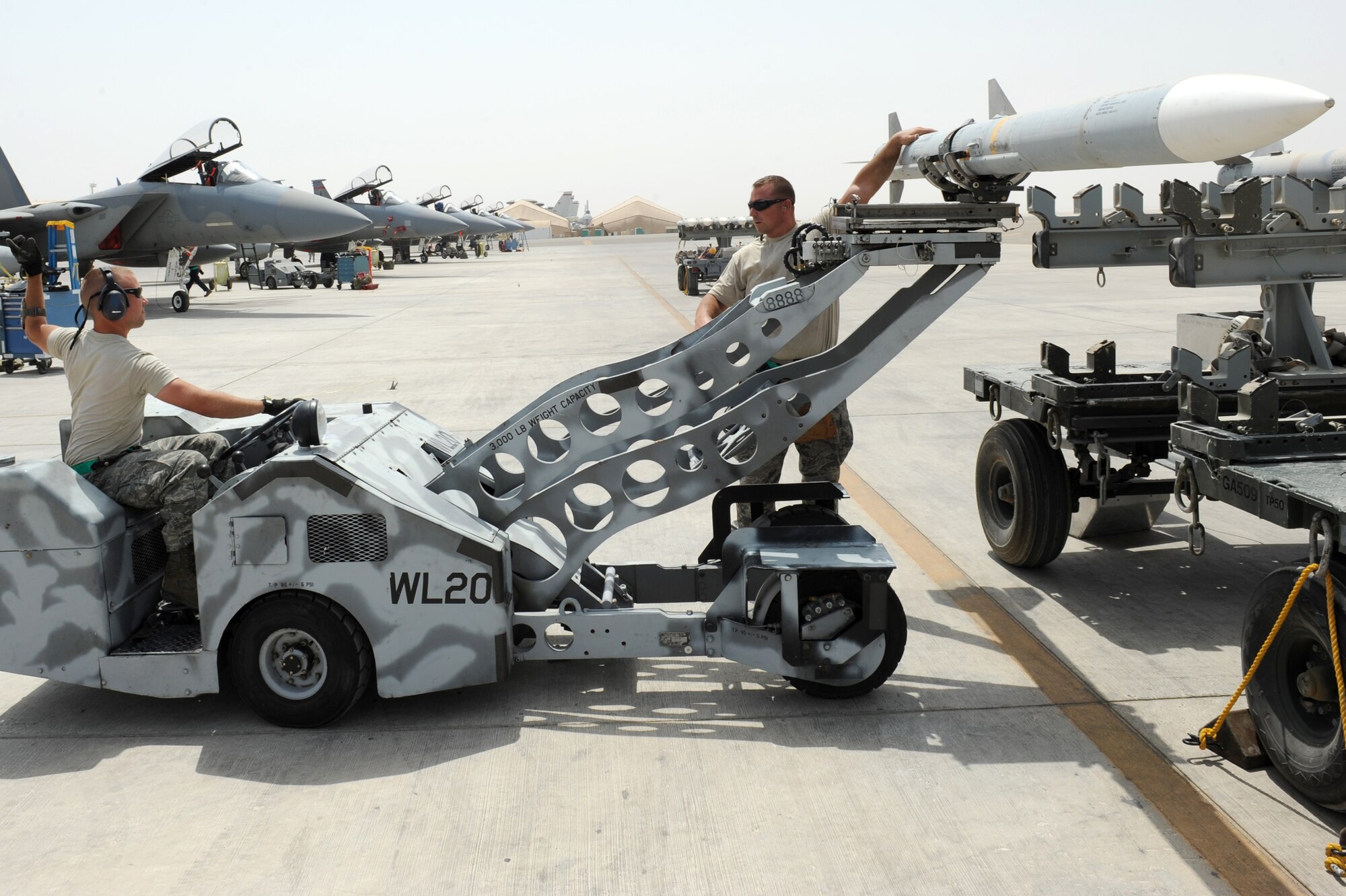 SOUTHWEST ASIA - U.S. Air Force Staff Sgt. Randy Millet signals as Tech. Sgt. Brandon Orr guides a missile off the carrier during a generation exercise at the 380th Air Expeditionary Wing Aug. 17, 2012. Orr and Millet, New Orleans natives, are 380th Expeditionary Aircraft Maintenance Squadron weapons loaders and are deployed from the Louisiana Air National Guard. (U.S. Air Force photo/Master Sgt. Scott MacKay)