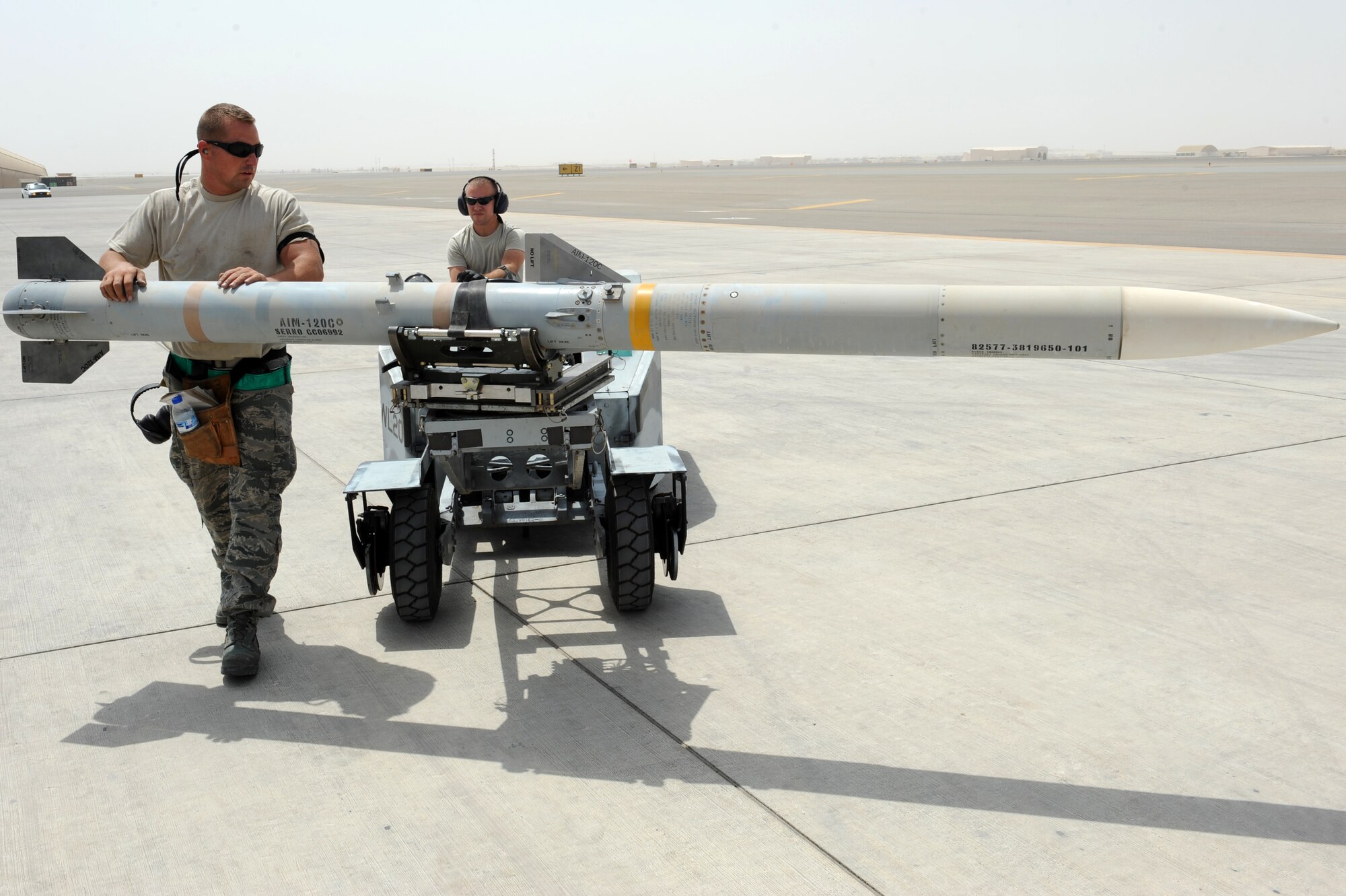 SOUTHWEST ASIA - U.S. Air Force Tech. Sgt. Brandon Orr guides a missile as Staff Sgt. Randy Millet drives it during a generation exercise Aug. 17, 2012. Orr and Millet, New Orleans natives, are 380th Expeditionary Aircraft Maintenance Squadron weapons loaders and are deployed to the 380th Air Expeditionary Wing from the Louisiana Air National Guard. (U.S. Air Force photo/Master Sgt. Scott MacKay)