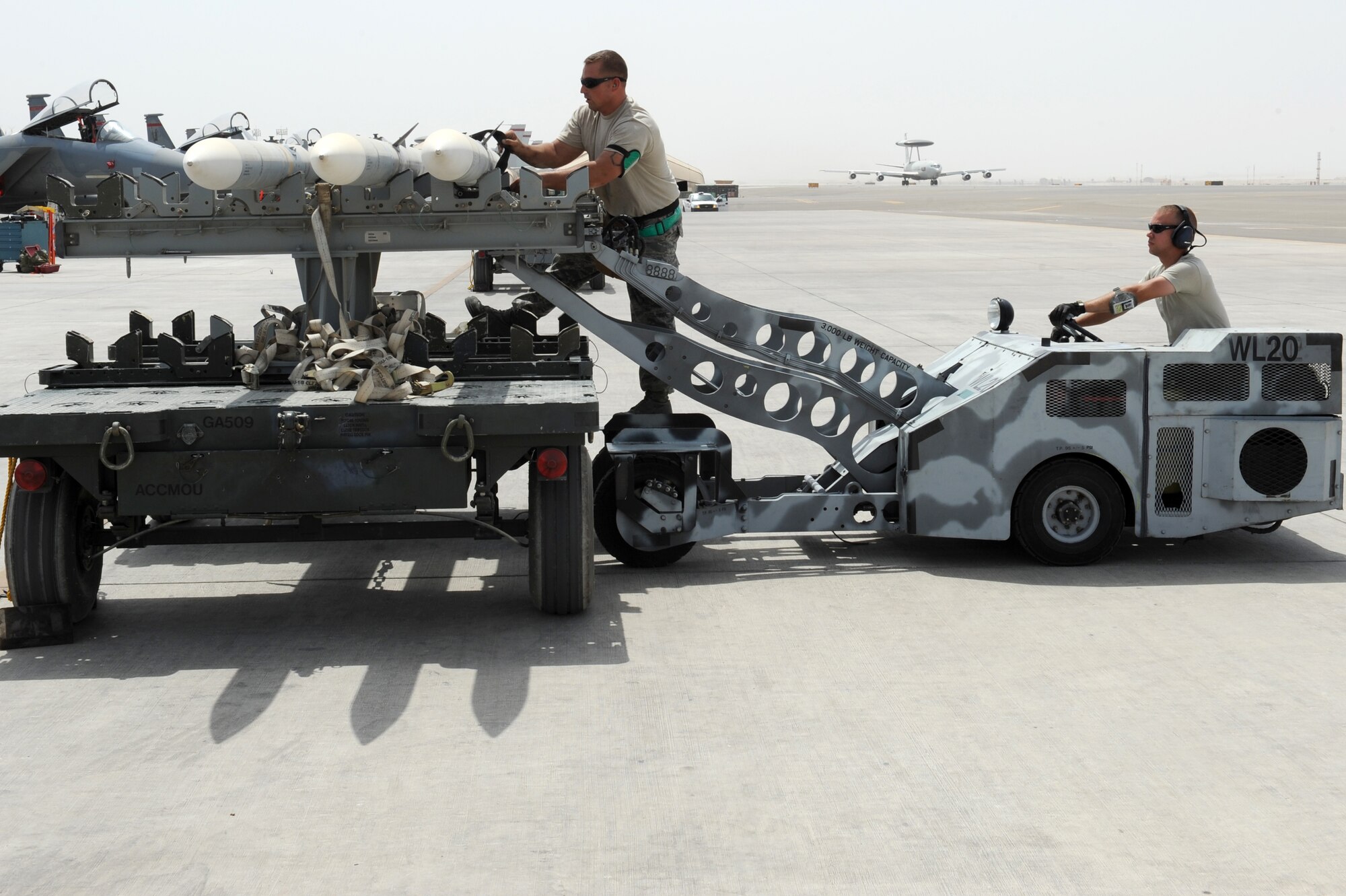 SOUTHWEST ASIA - U.S. Air Force Tech. Sgt. Brandon Orr secures a missile as Staff Sgt. Randy Millet waits to move it during a generation exercise Aug. 17, 2012. Orr and Millet, New Orleans natives, are 380th Expeditionary Aircraft Maintenance Squadron weapons loaders and are deployed to the 380th Air Expeditionary Wing from the Louisiana Air National Guard.  (U.S. Air Force photo/Master Sgt. Scott MacKay)