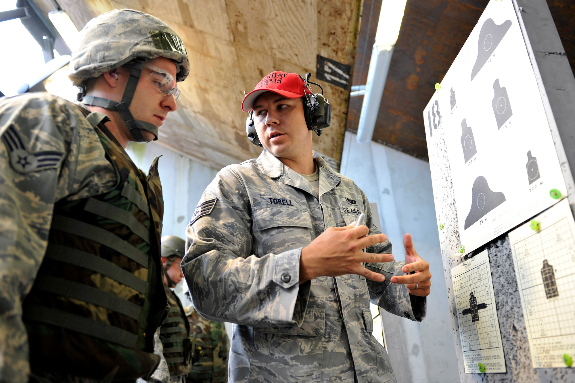 Staff Sgt. Jake Torell, 569th Combat Arms Training and Maintenance instructor, gives advice on shooting fundamentals along with sight corrections to a student at Vogelweh Military Complex, Germany, Aug. 9, 2012.  The 569th CATM instructors attend a nine-week certification course at the Security Forces Academy at Lackland Air Force Base, Texas, specializing in professional firearms. (U.S. Air Force photo/Senior Airman Chris Willis)