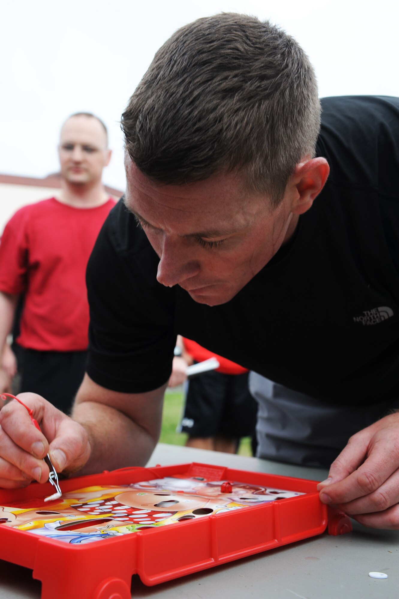 U.S. Air Force Capt. Chad Willis, 35th Aerospace Medical Squadron optometrist, pulls out a game piece from the game "Operation" during a 35th Medical Group warrior medic challenge at Misawa Air Base, Japan, Aug. 17, 2012. Airmen had to pull out six pieces to move to the next station, and if the game buzzed, they had to do three burpies. To boost morale, four squadrons from the 35 MDG showcased their fitness skills to see who would dominate the competition. (U.S. Air Force photo by Airman 1st Class Kia Atkins/Released)