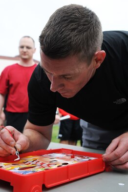 U.S. Air Force Capt. Chad Willis, 35th Aerospace Medical Squadron optometrist, pulls out a game piece from the game "Operation" during a 35th Medical Group warrior medic challenge at Misawa Air Base, Japan, Aug. 17, 2012. Airmen had to pull out six pieces to move to the next station, and if the game buzzed, they had to do three burpies. To boost morale, four squadrons from the 35 MDG showcased their fitness skills to see who would dominate the competition. (U.S. Air Force photo/Airman 1st Class Kia Atkins) 

