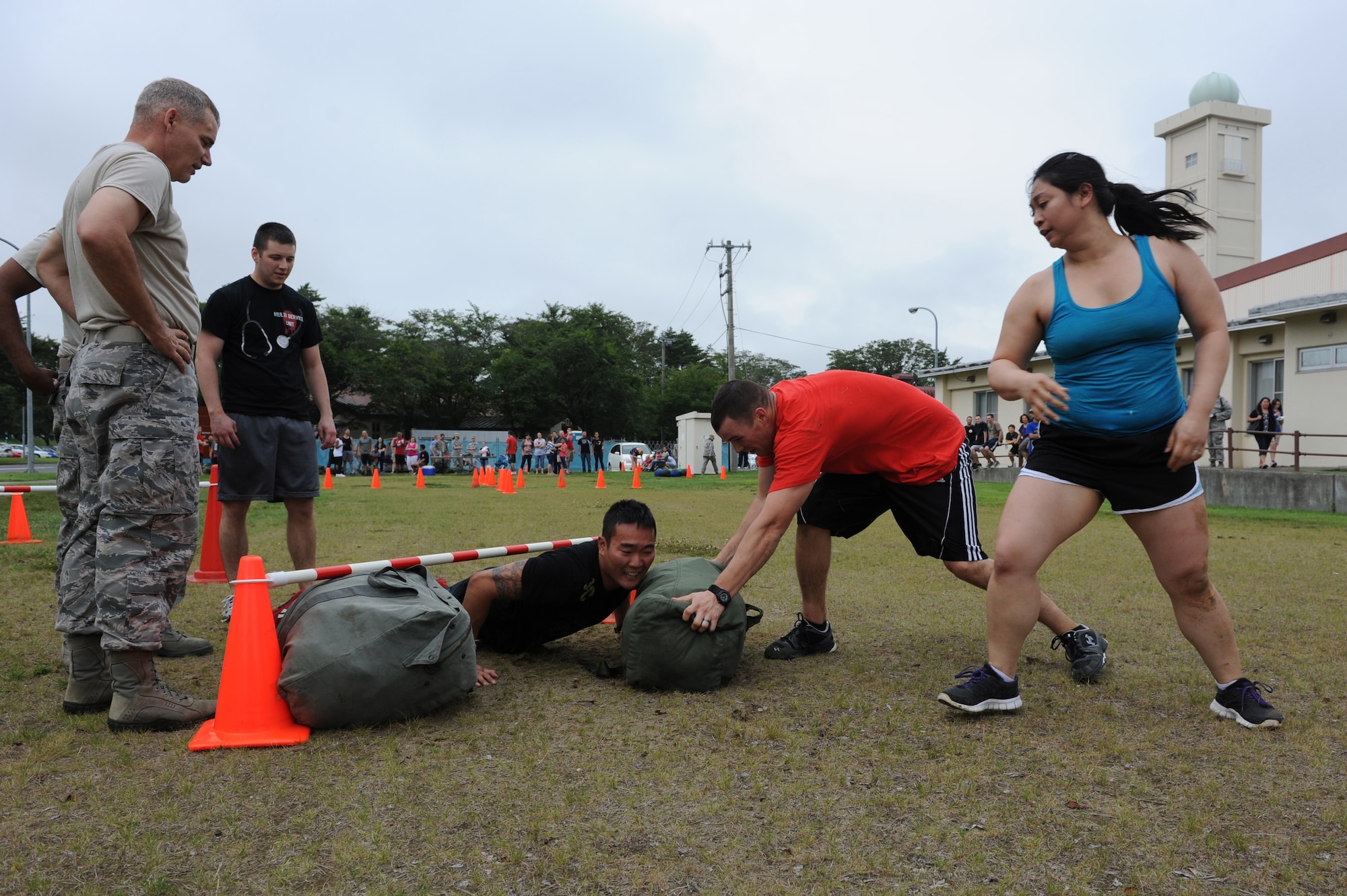 U.S. Air Force Airmen from the 35th Surgical Squadron and Chief Master Sgt. James Laurent, left, 35th Fighter Wing command chief, carried their C-1 chemical protection bags under and over obstacles during the 35th Medical Group warrior medic challenge at Misawa Air Base, Japan, Aug. 17, 2012. In this morale boosting timed-challenge, four squadrons from the 35 MDG competed for a trophy and bragging rights for their units. (U.S. Air Force photo by Airman 1st Class Kia Atkins/Released