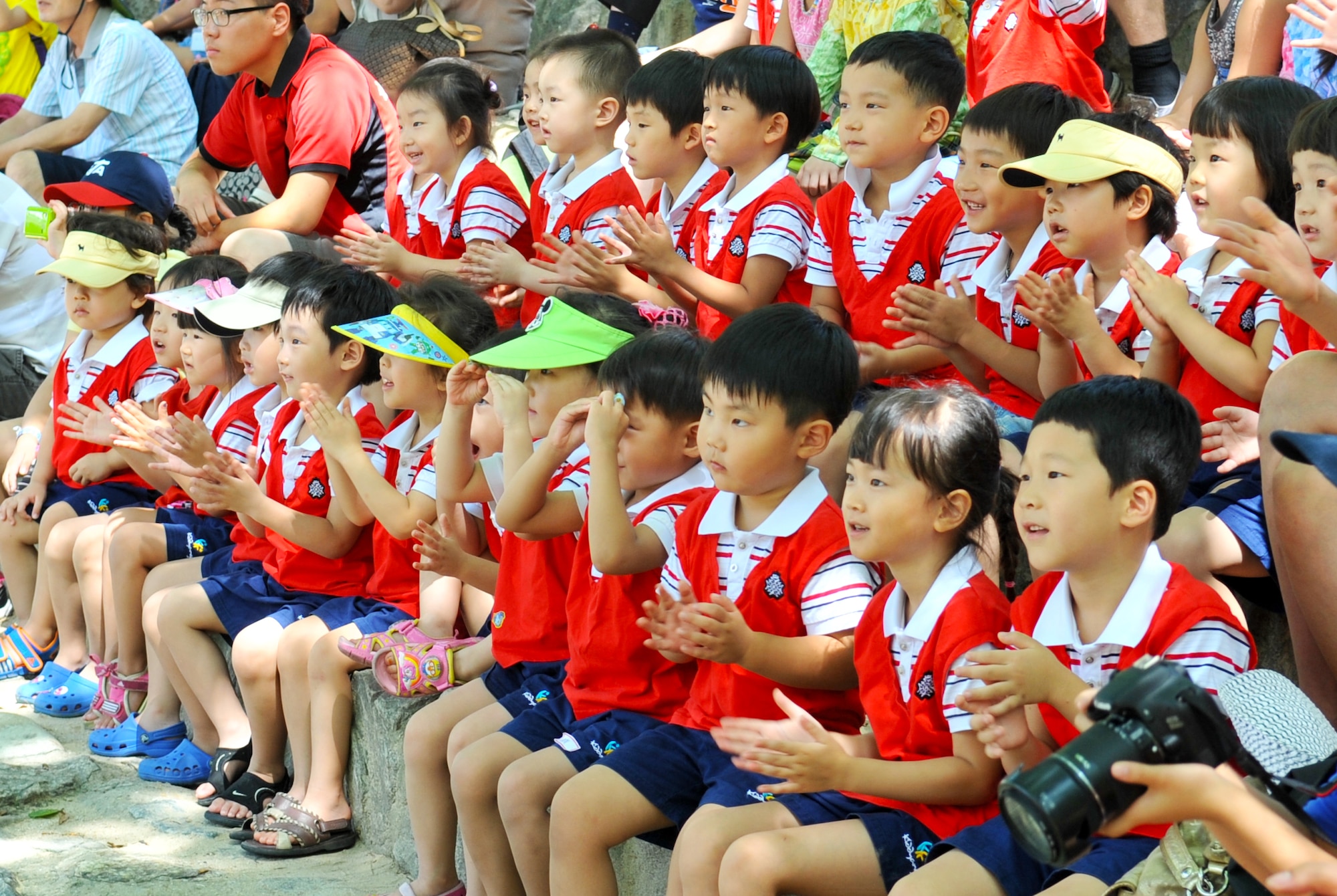 Children watch and cheer as a tightrope walker performs acrobatics at the Korean Folk Village Aug. 17, 2012. Throughout the day, the village comes to life with a selection of vibrant performances that give spectators a view into this ancient culture with traditional wedding ceremonies, equestrian shows, tightrope acrobatics and a traditional farmer’s music and dance show. (U.S. Air Force photo/Staff Sgt. Stefanie Torres)