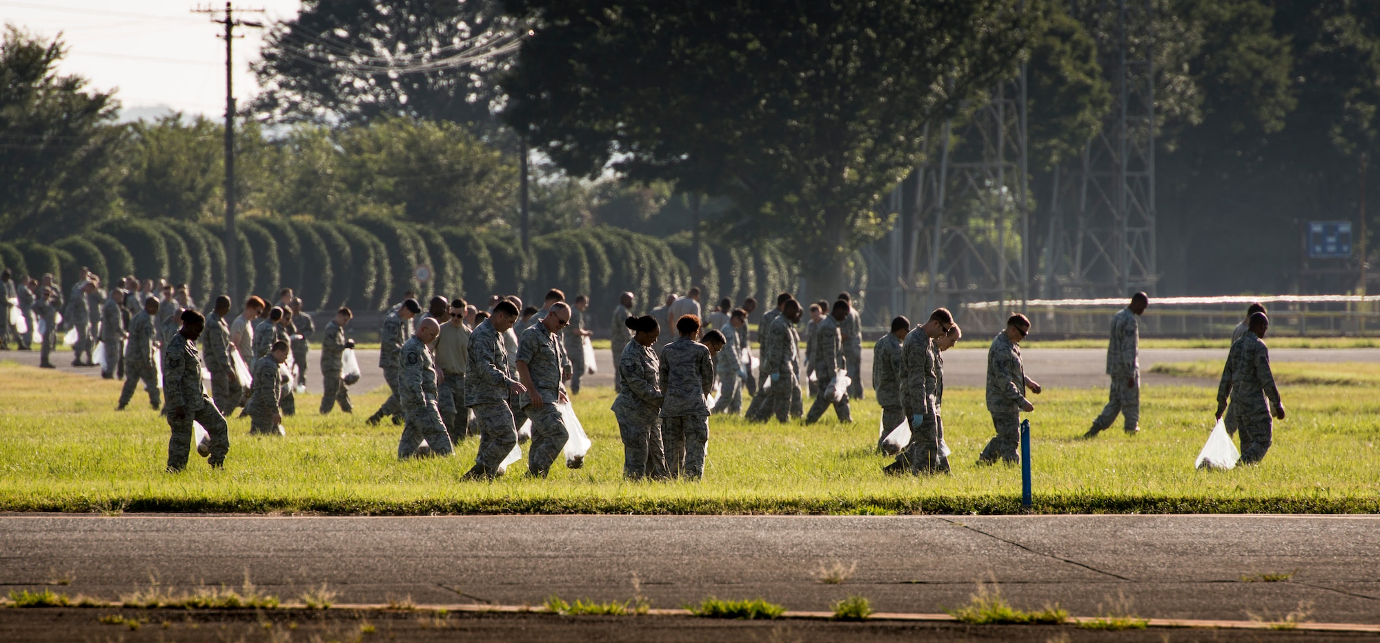 YOKOTA AIR BASE, Japan -- Airmen pick up debris left by the previous night's fireworks at Yokota Air Base, Japan, Aug. 20, 2012. Airmen from across the base participated in cleaning the flightline to help prevent aircraft damage. (U.S. Air Force photo by Tech. Sgt. Samuel Morse)