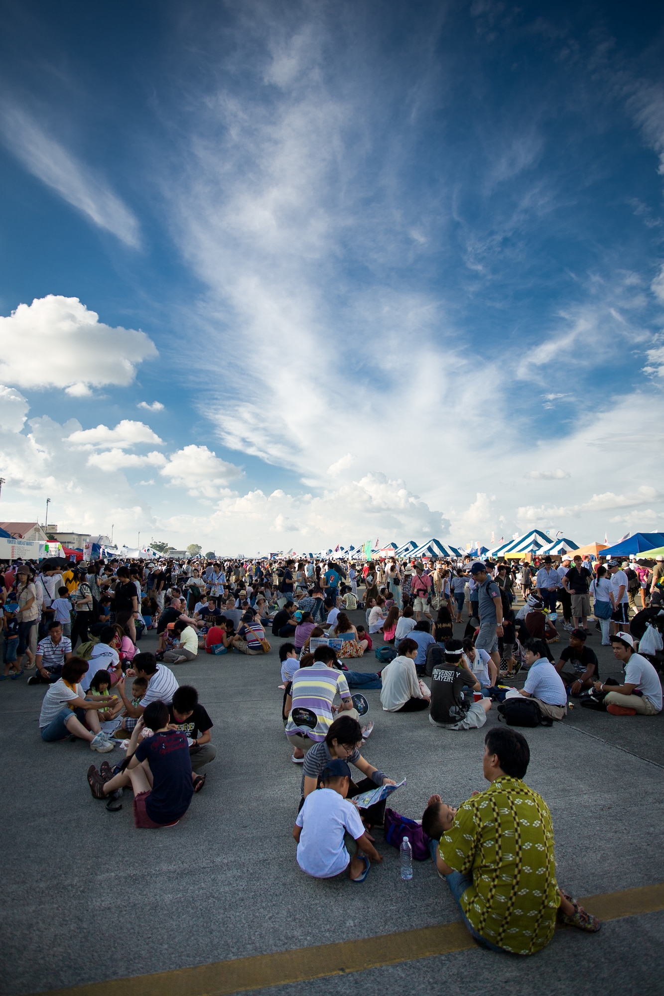 YOKOTA AIR BASE, Japan -- People sit and eat in the late afternoon shadow of Hangar 15 at the 2012 Japanese-American Friendship Festival, Yokota Air Base, Japan, Aug. 18, 2012. Many people looked for ways to stay out of the sun when the sky cleared following the thunderstorm. (U.S. Air Force photo/Staff Sgt. Josh Voyles)