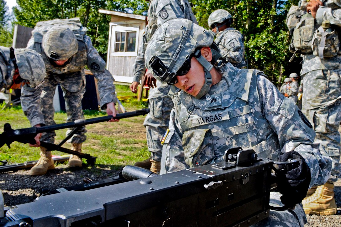 Army Sgt. Yesenia Vargas, center, demonstrates how to conduct a functions check of an M2 .50-caliber machine gun on Joint Base Elmendorf-Richardson, Alaska, Aug. 14, 2012. Vargas is assigned to the 95th Chemical Company.