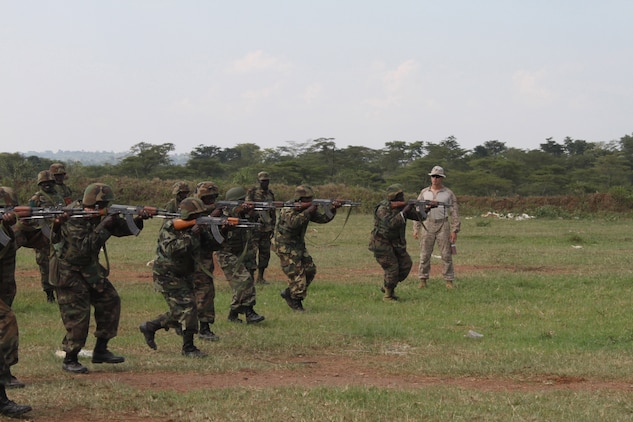 Soldiers with the Uganda People's Defense Force move forward with weapons at the ready as a training team of U.S. Marines coaches them in small unit tactics and marksmanship.  The Uganda forces are expecting to participate in the African Union Mission in Somalia.  The Marines are made up of members of the 24th Marine Expeditionary Unit and Special Purpose Marine Air Ground Task Force 12.