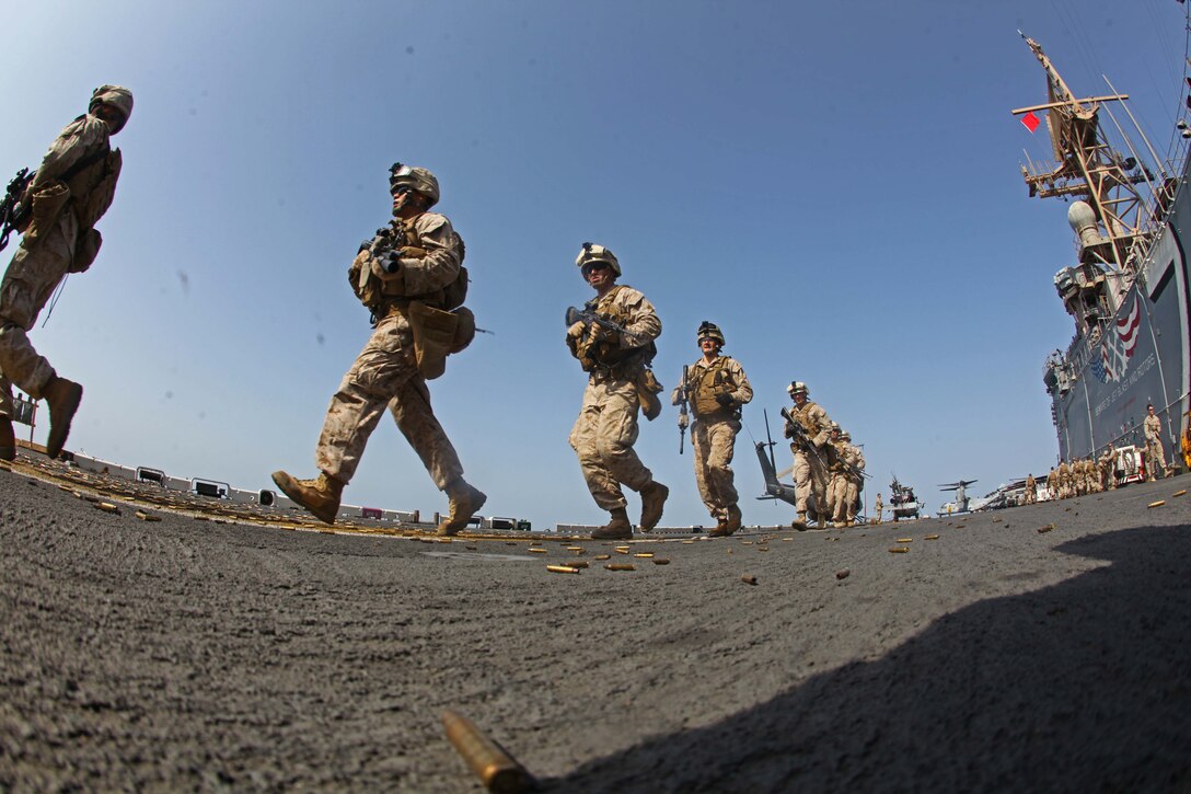 Marines with Battalion Landing Team 1st Battalion, 2nd Marine Regiment, 24th Marine Expeditionary Unit, move to their firing positions prior to conducting a multiple target, live-fire range on the flight deck of USS Iwo Jima, Aug. 19, 2012. The Marines conduct various live fire ranges while underway to keep their skills sharp during deployment. The 24th MEU is deployed with the Iwo Jima Amphibious Ready Group as a theater reserve force for U.S. Central Command and is providing support for maritime security operations and theater security cooperation efforts in the U.S. Navy's 5th Fleet area of responsibility.