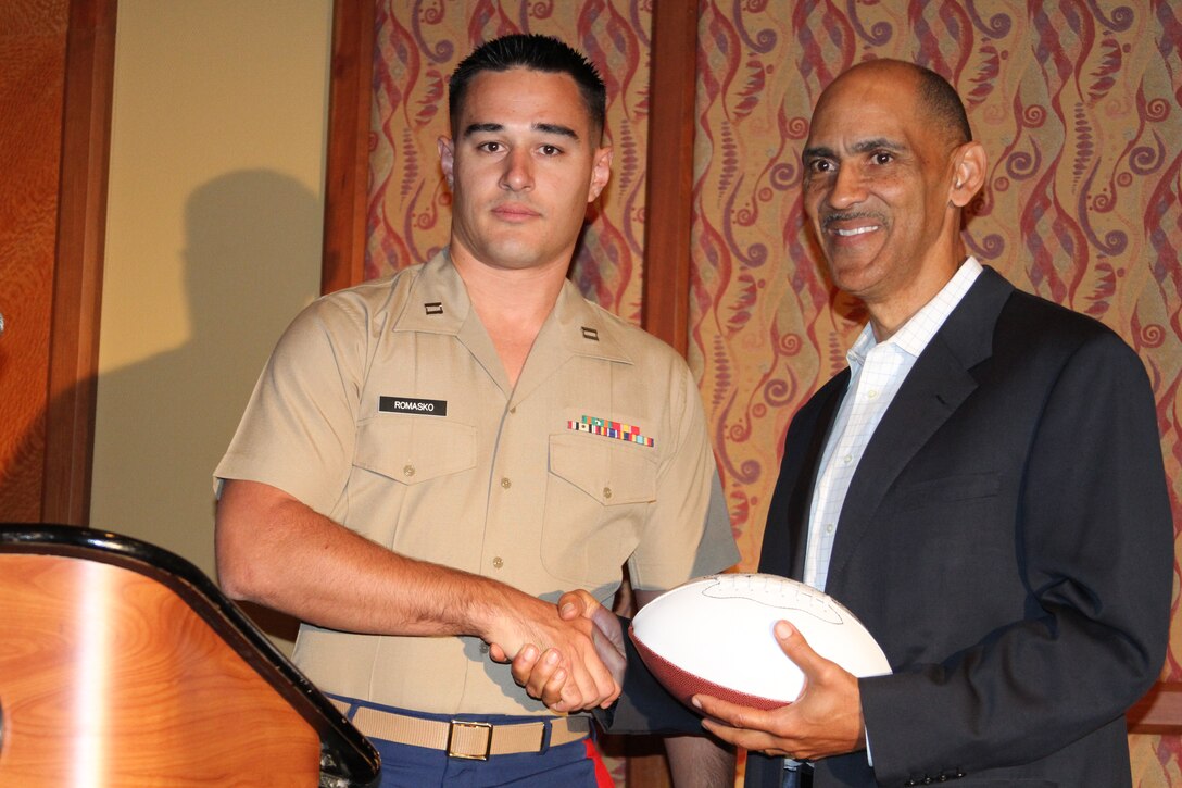 Capt. Ryan Romasko, officer selection officer, RS Orlando, presents a Marines football to "Tony" Dungy, an NBC football analyst,and former Indianapolis Colts head coach, during the 2012 Black Coaches Asociation conference in Orlando, Fla. 