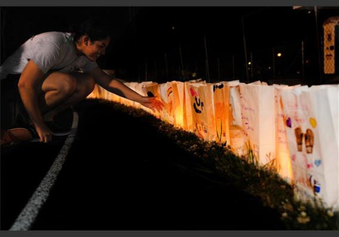 Daniela Pimentel, a member of the 6MCD Pacesetter group, lights a luminaria bag during a Relay for Life function at Beaufort Middle School, SC, Apr. 27.  Relay For Life participants, survivors and caregivers remember loved ones lost to cancer and honor those battling the disease through this ceremony. 