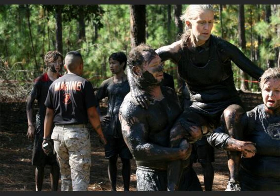 A team performs a modified fireman carry towards the end of the USMC Ultimate Challenge Mud Run course in Columbia, S.C., Oct. 15. Teams were made up of four participants each and include categories such as JROTC, Military, Homeland Heroes and Open Coed. (Official USMC photo by Cpl. Chris Kutlesa)