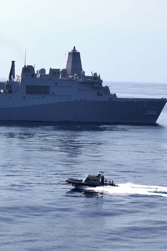 A rigid-hull inflatable boat passes the USS Green Bay after transporting servicemembers from the USS Rushmore, Aug. 18, during the 15th Marine Expeditionary Unit and Peleliu Amphibious Ready Groupâ€™s final pre-deployment training evolution, Certification Exercise. The MEUâ€™s mission capabilities and performance will be evaluated during the exercise to ensure it is ready to deploy later this year.