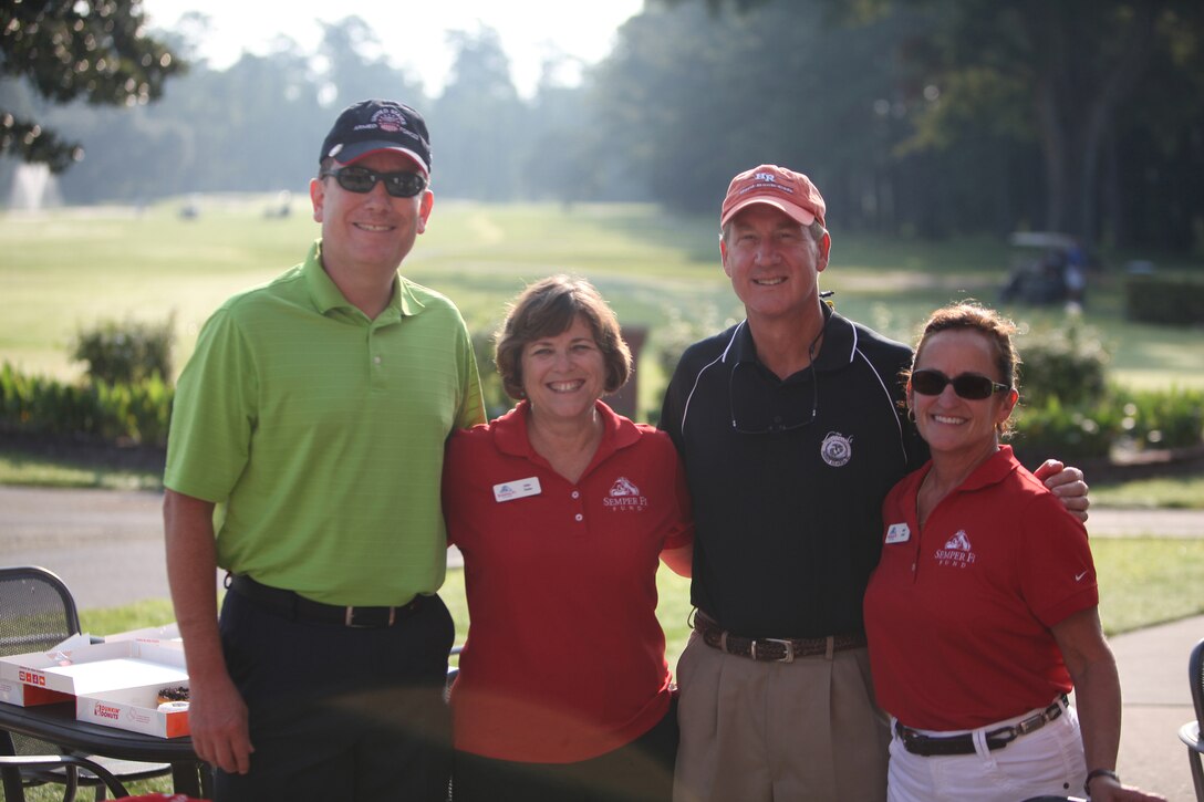 (from left to right) Navy Capt. Francisco R. Leal, the commanding officer of 2nd Dental Battalion, Halen Toolan, one of the founders of the Injured Marine Semper Fi Fund, James J. Ware, a retired Navy captain and dental officer, and Dale Land, a community outreach representative for the Injured Marine Semper Fi Fund, pose for a picture during a battalion golf tournament aboard Camp Lejeune, N.C., Aug. 17, 2012. The tournament was part of the Navy Dental Corps’ 100th anniversary celebration.  The command took the opportunity to build camaraderie and also collect money to help wounded warriors. The sailors raised approximately $1700 to donate to the fund.