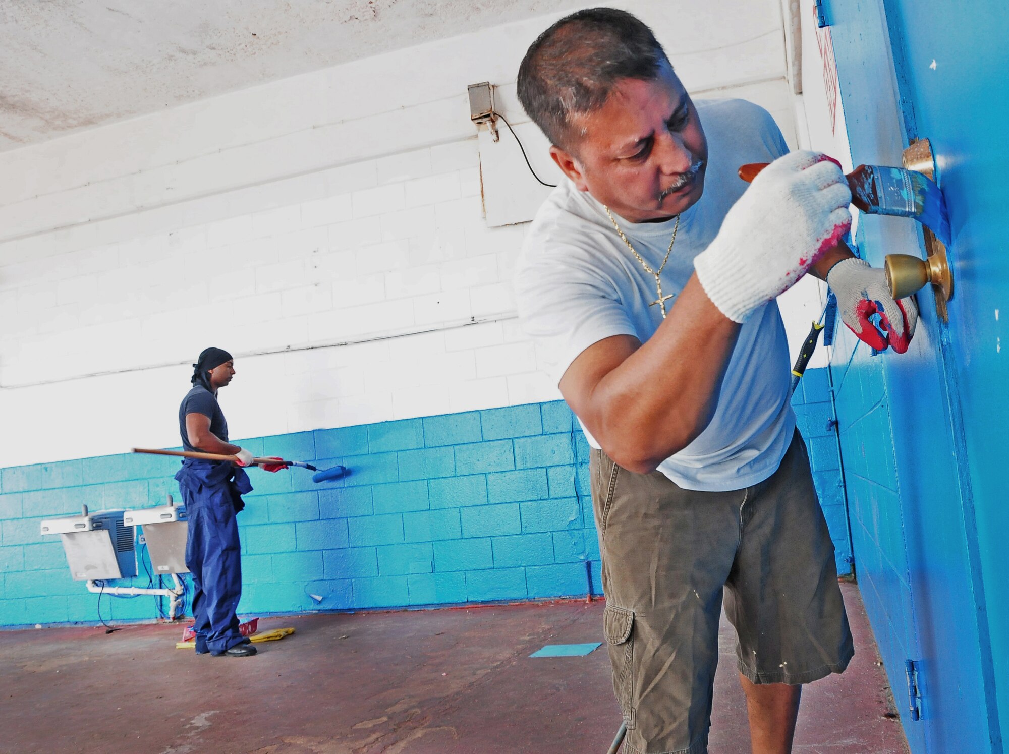 YIGO, Guam — Staff. Sgt. Sidney Okagu (left), 36th Mobility Response Squadron mobile command and control (C-2) controller, and Kent Espinosa, Francisco B. Leon Guerrero middle school aid, repaints the walls of the school during a campus clean up here, Aug. 2. The 36th Wing Airmen helped school staff clean and paint the school in order to get the campus ready for the incoming school year. (U.S. Air Force photo by Airman 1st Class Marianique Santos/Released)