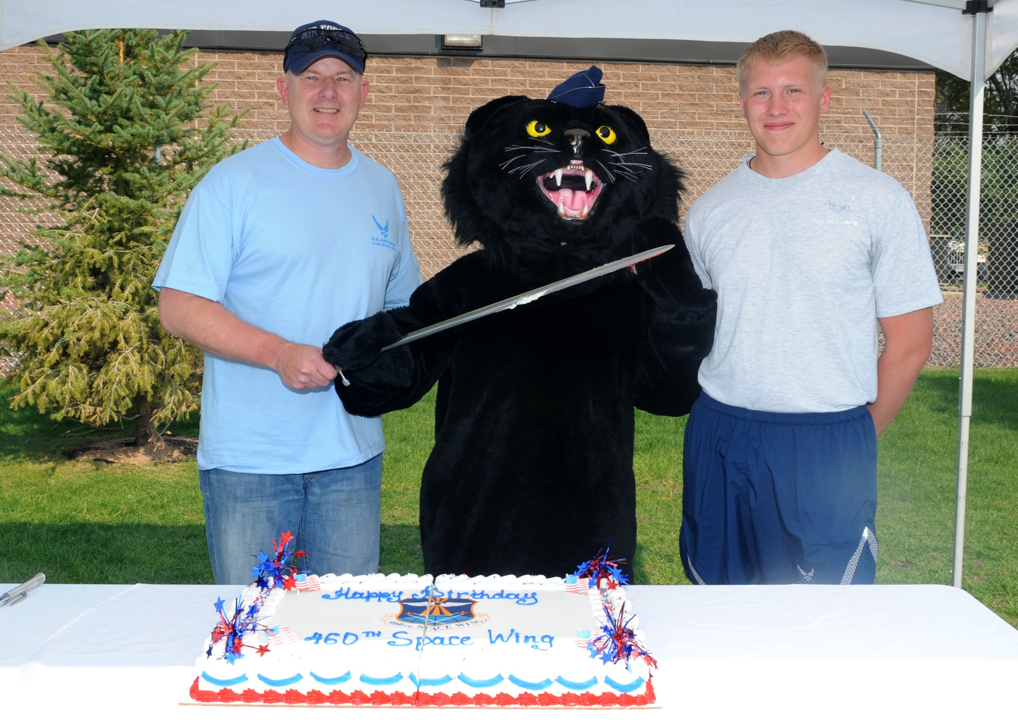 BUCKLEY AIR FORCE BASE, Colo. – Col. Daniel Dant, 460 Space Wing commander, stands with Airman Zachary Canarr, a volunteer from the 2nd Space Warning Squadron, and Buck Lee, the base mascot, after cutting the birthday cake during Fun Fest Aug. 17, 2012.  The 460th Space Wing celebrated its eighth birthday with Fun Fest, a day filled with sport competitions and a community fair.  (U.S. Air Force photo by Senior Airman Marcy Glass)